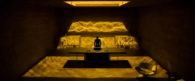 Woman standing in an office covered in yellow light