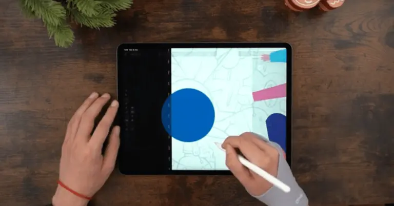 Male hands drawing on an iPad positioned on a wooden table
