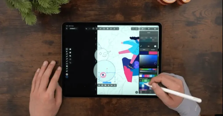 Male hands drawing on an iPad positioned on a wooden table