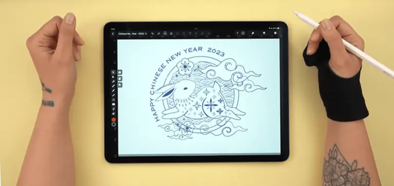 Hands drawing a Chinese New Year 2023 greeting on a digital tablet