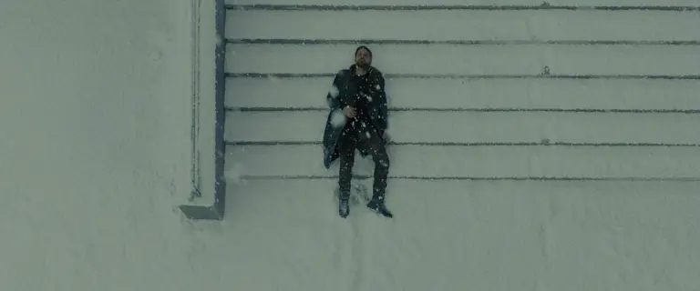Man covered in snow lying on stairs