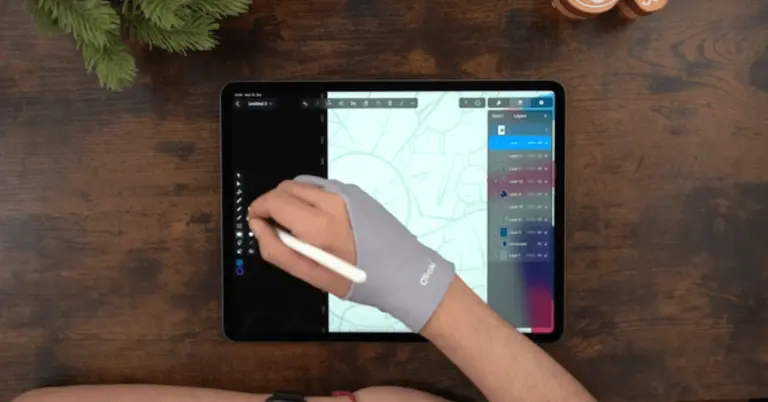 Male hands drawing on an iPad positioned on a wooden table
