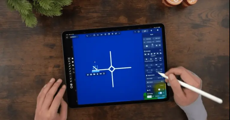 Male hands drawing on an iPad positioned on a wooden table