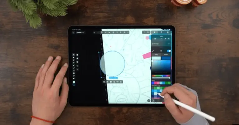Male hands drawing on an iPad positioned on a wooden table