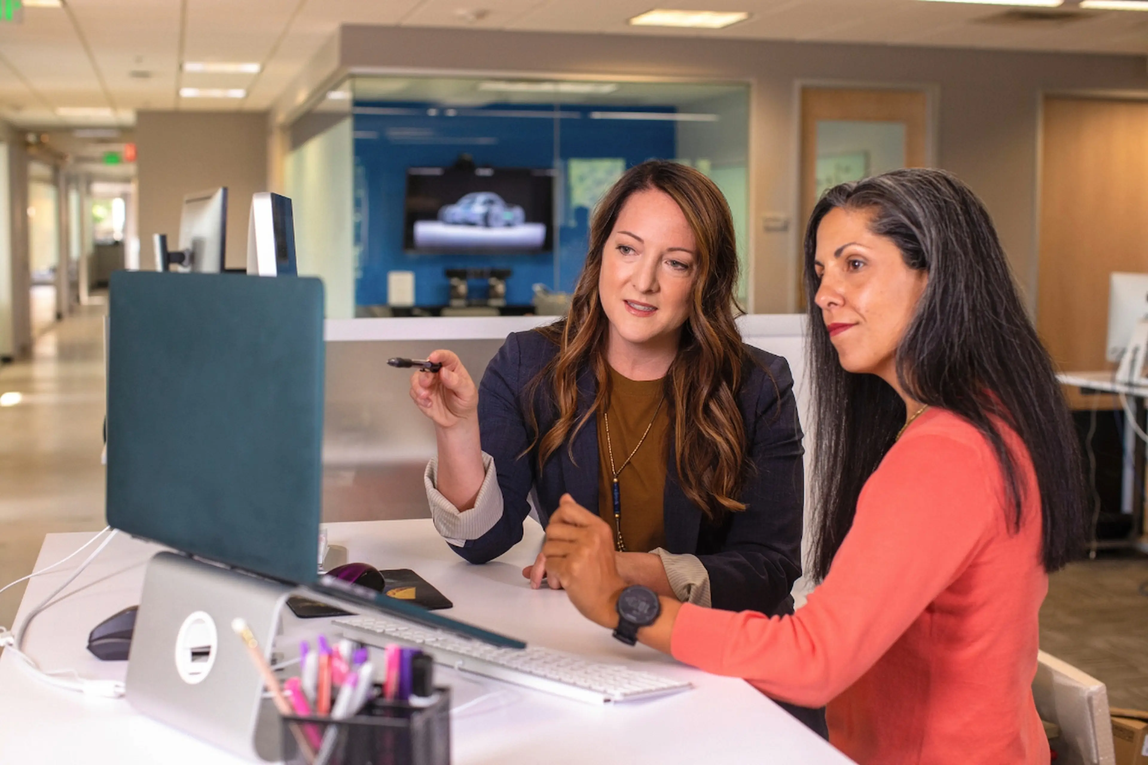 Two lawyers discussing a case; one of them is pointing at a laptop screen.