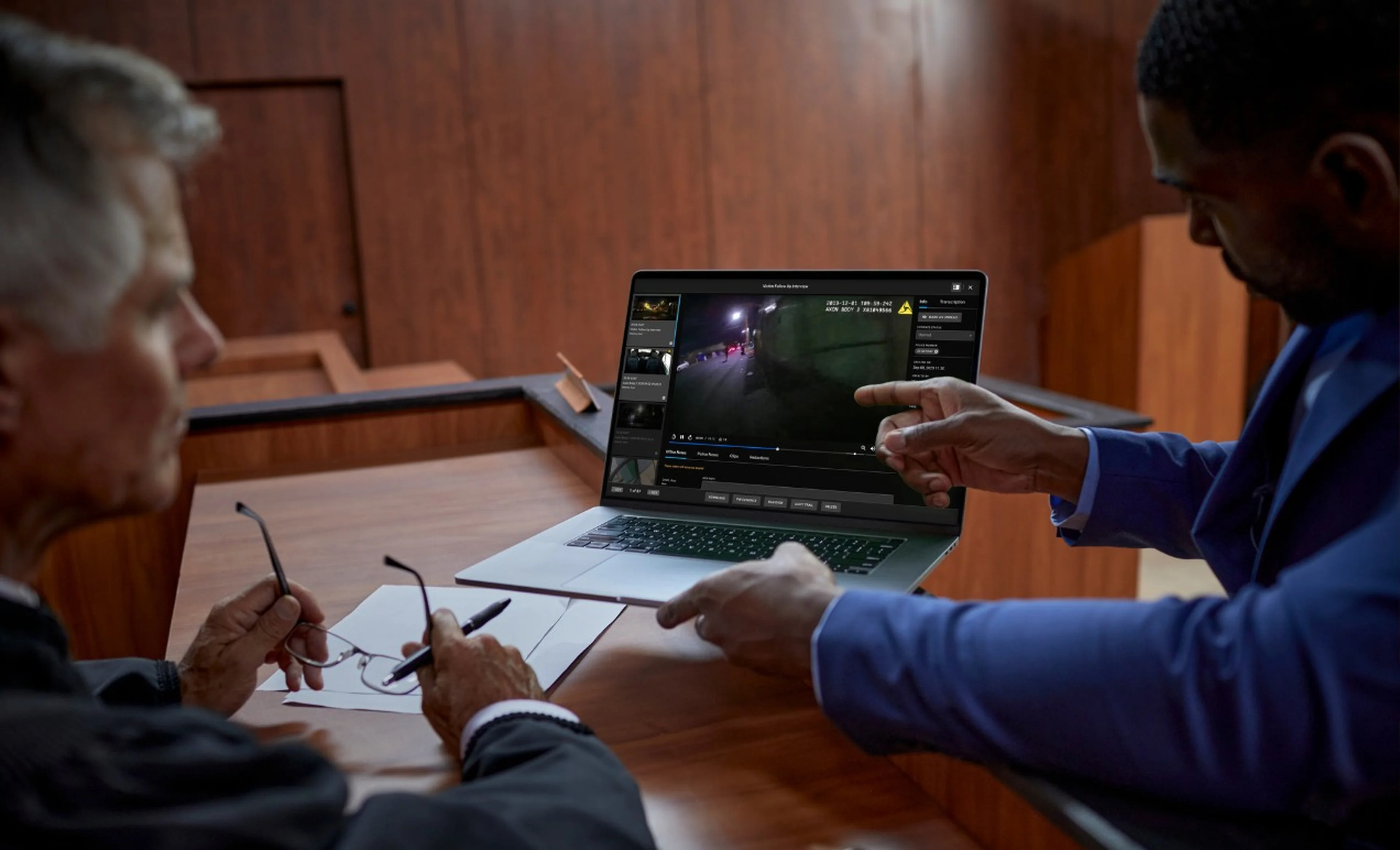 Someone showing a video clip to a judge in a courtroom.
