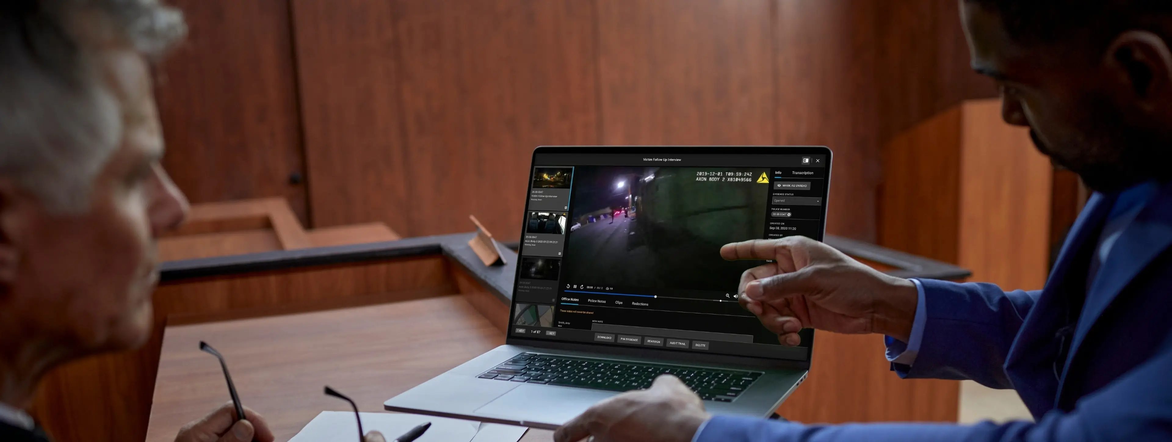 Someone showing a video clip to a judge in a courtroom.