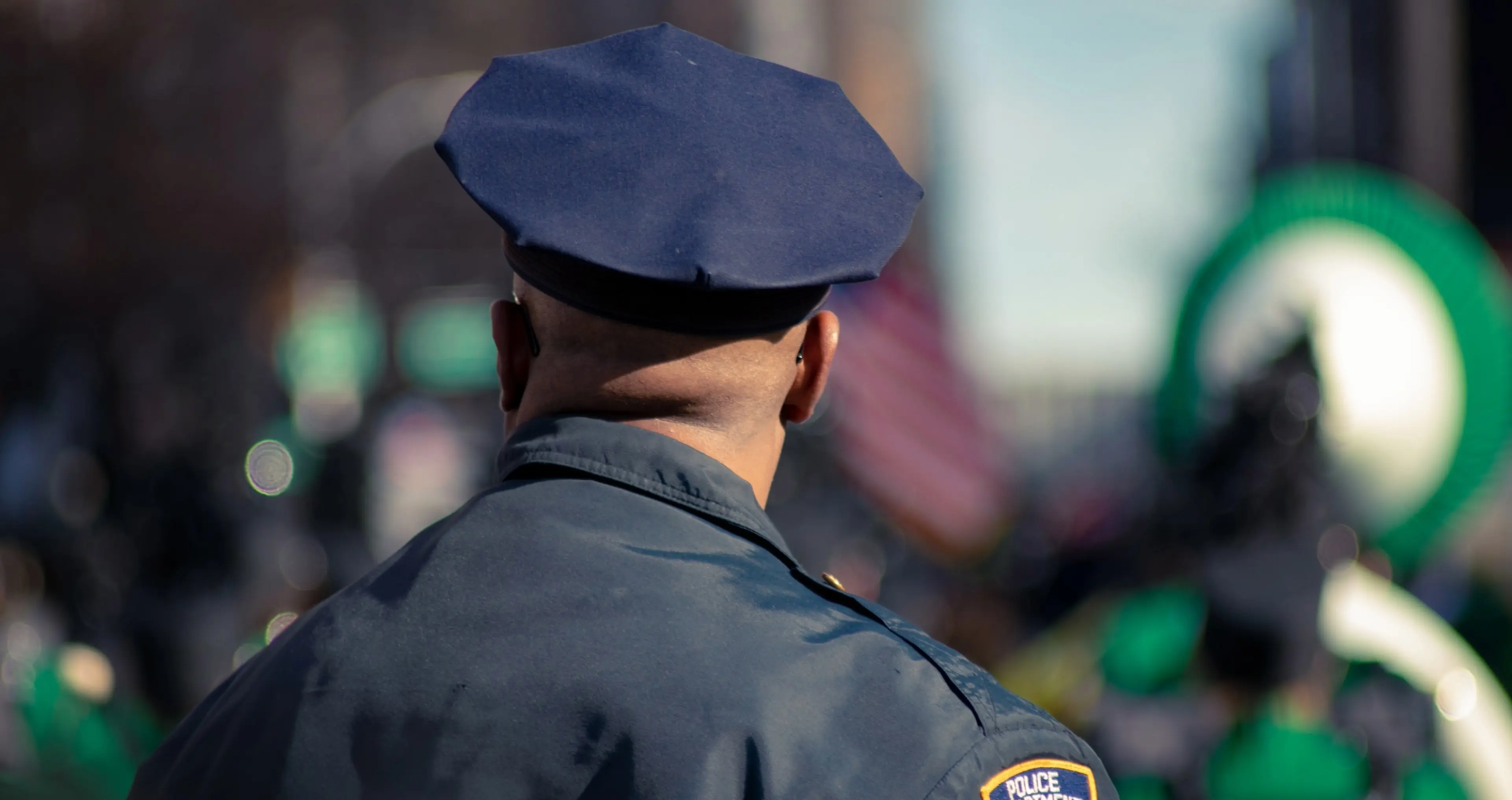 A police officer in front of a brightly colored background.