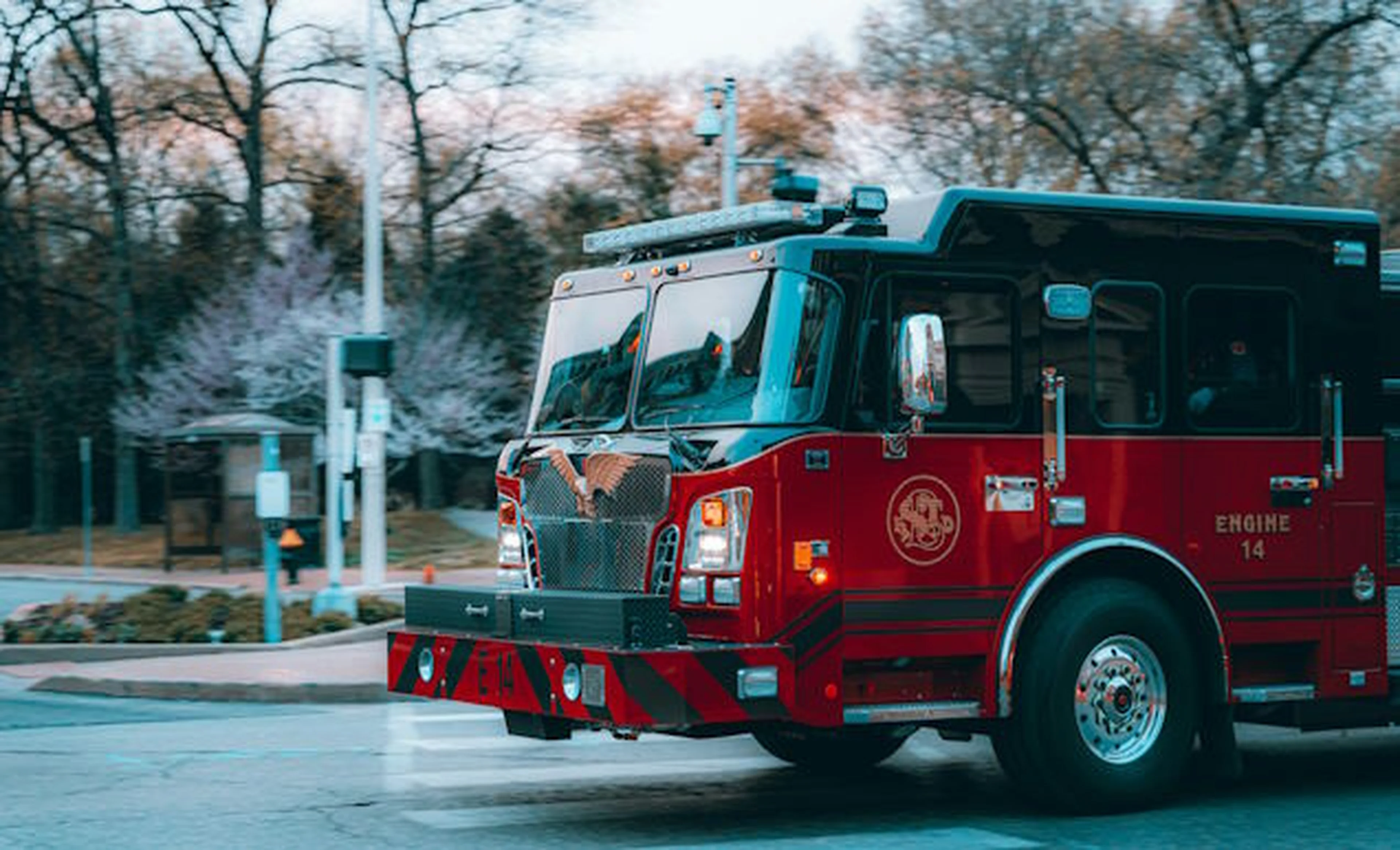 A firetruck turns a corner on a winter day.