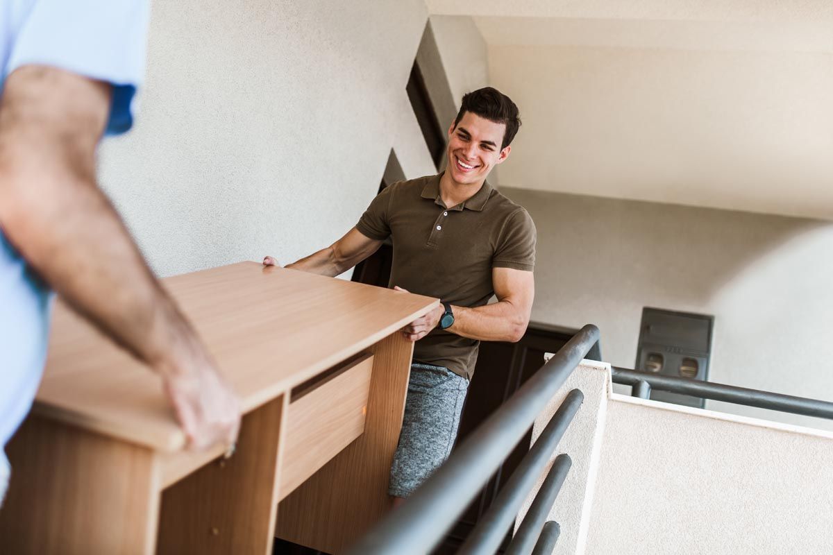 two men carrying furniture down the stairs