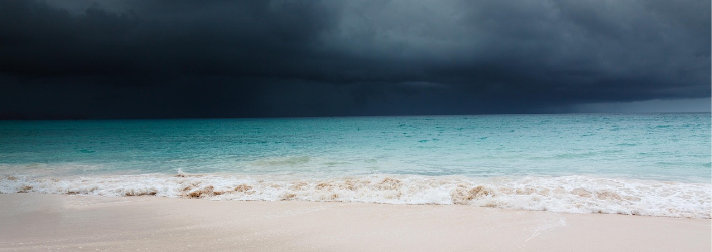Mooi strand met donkere wolken