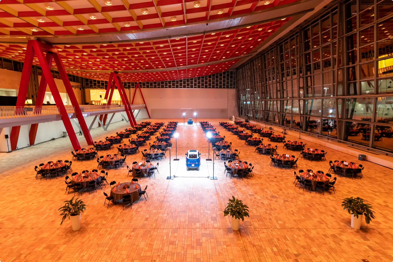Large spacious room with round tables and car in the middle