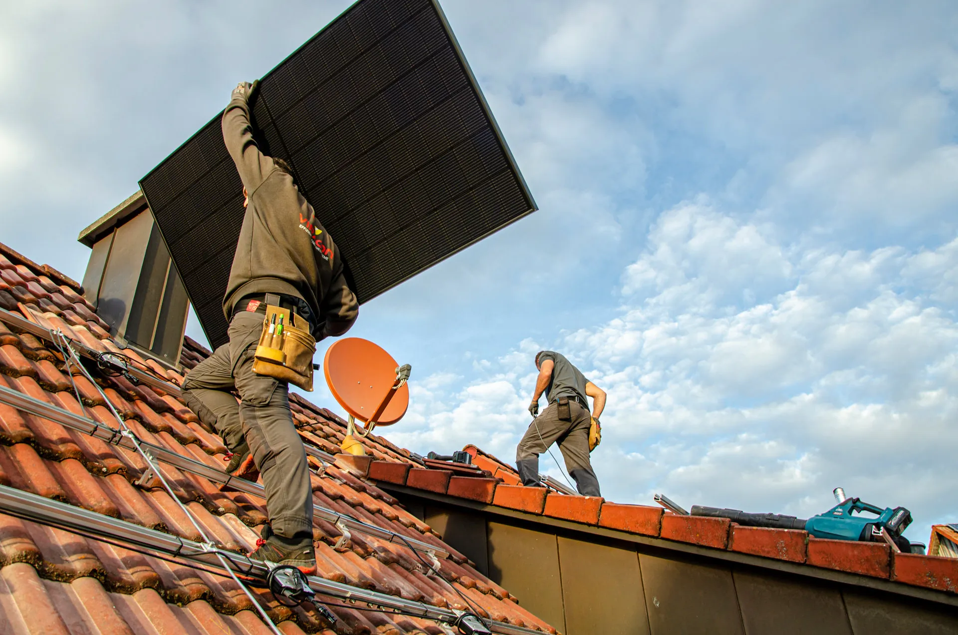 Viracon Mitarbeiter mit Photovoltaikmodul bei Montage auf dem Dach