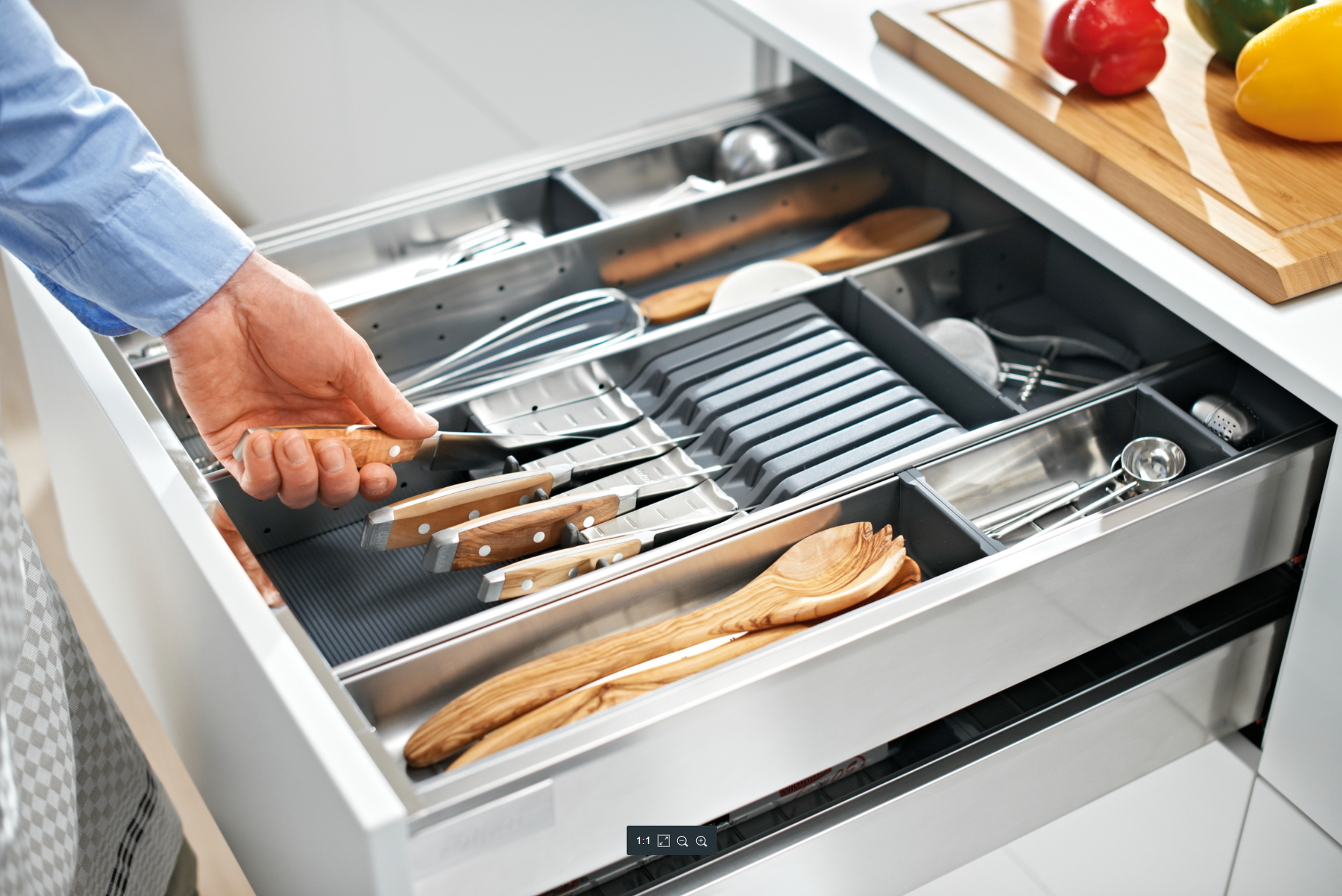 A person using their left hand to remove a knife from an ORGA-LINE knife holder by Blum.