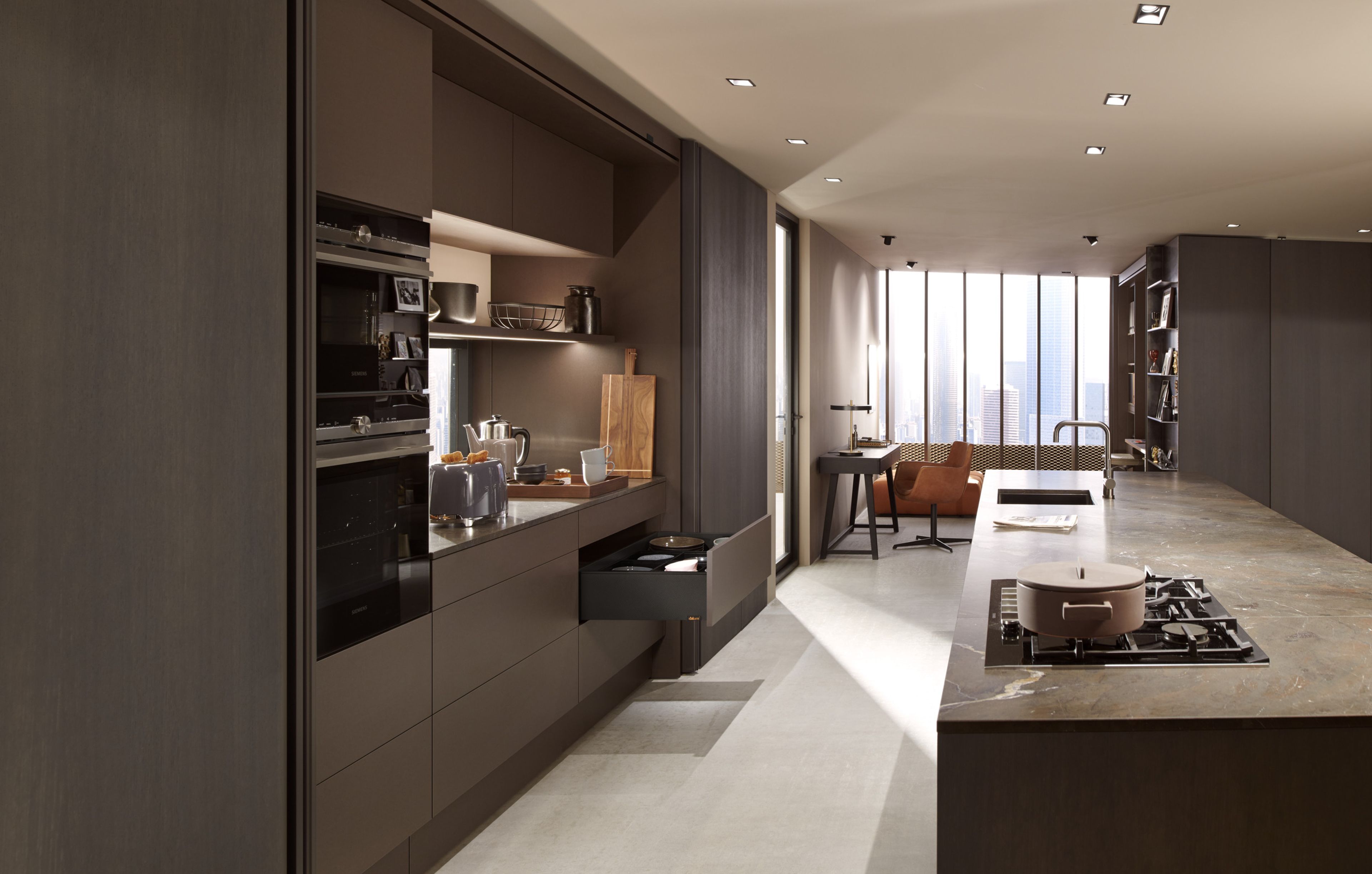 An open drawer with black sides in an island kitchen with dark brown cabinetry