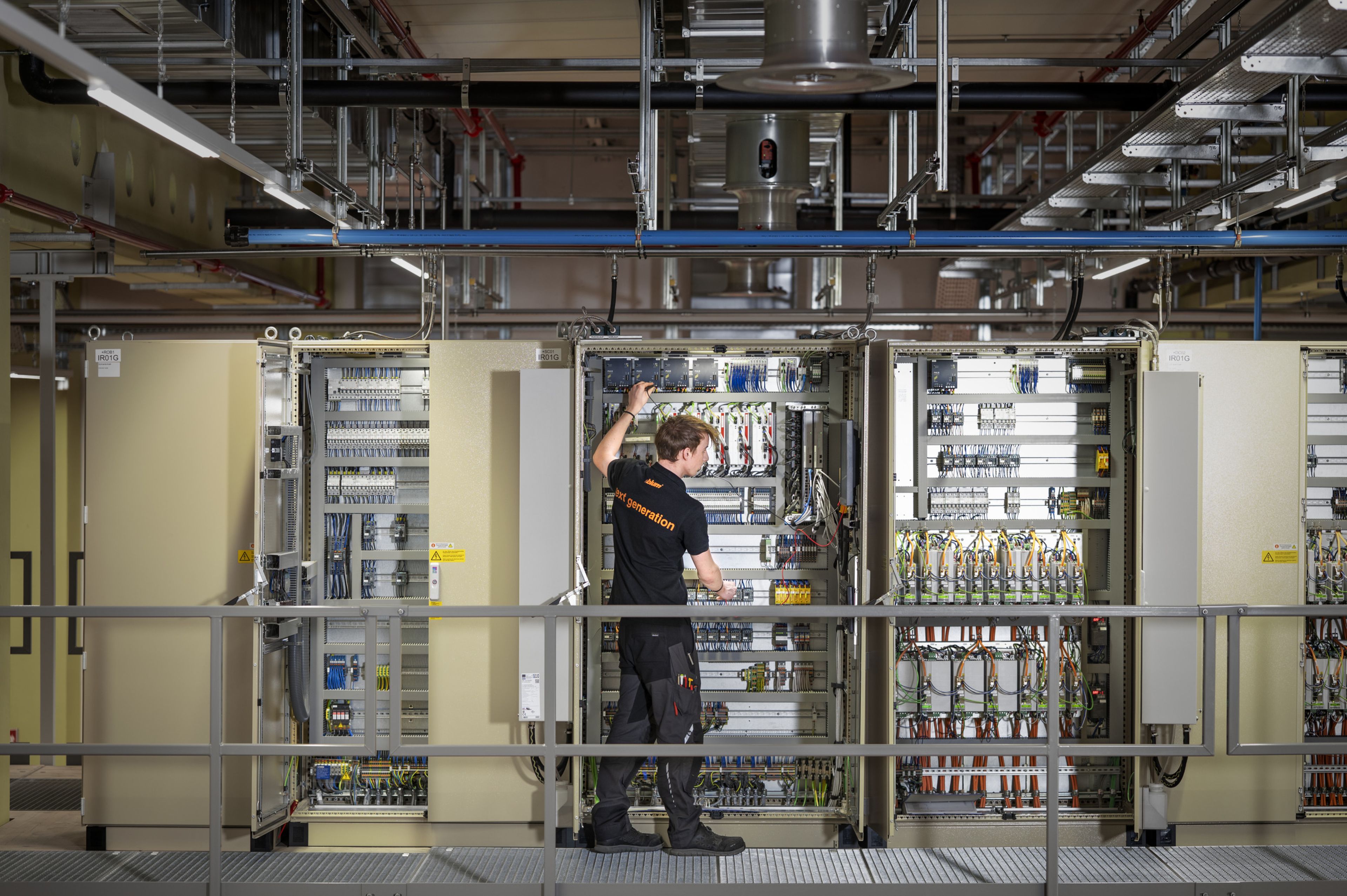 Auszubildende in der Mechatronik arbeiten an einem Schaltschrank und installieren sowie prüfen elektrische Komponenten, Steuerungen und Verdrahtungen im industriellen Umfeld.