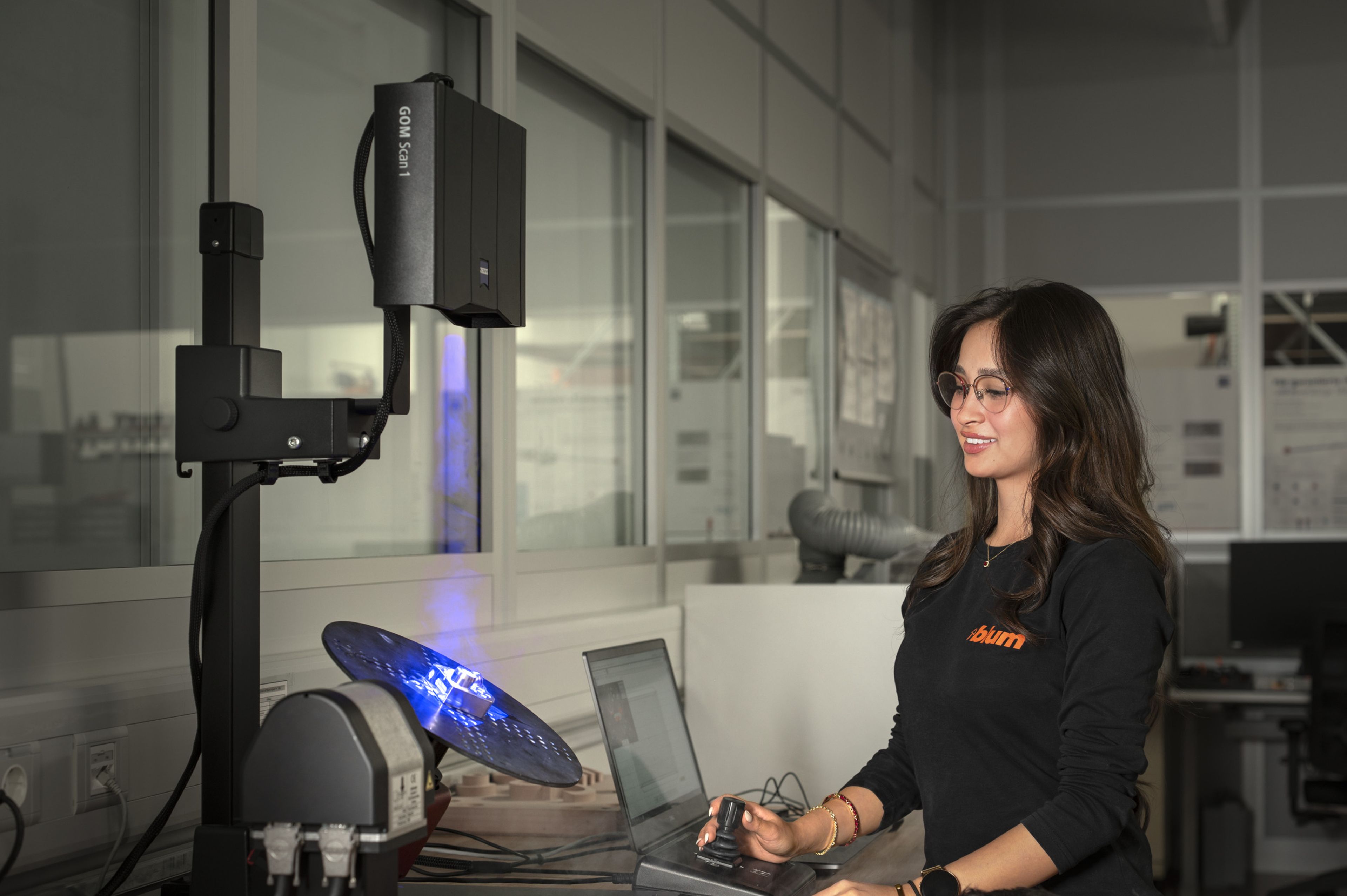 Auszubildende in der Ausbildung bei Blum im Beruf Fertigungsmesstechnik digitalisieren ein Bauteil mit einem Streifenlichtprojektor, steuern den Messvorgang am Computer und erfassen die Daten für die digitale Auswertung.