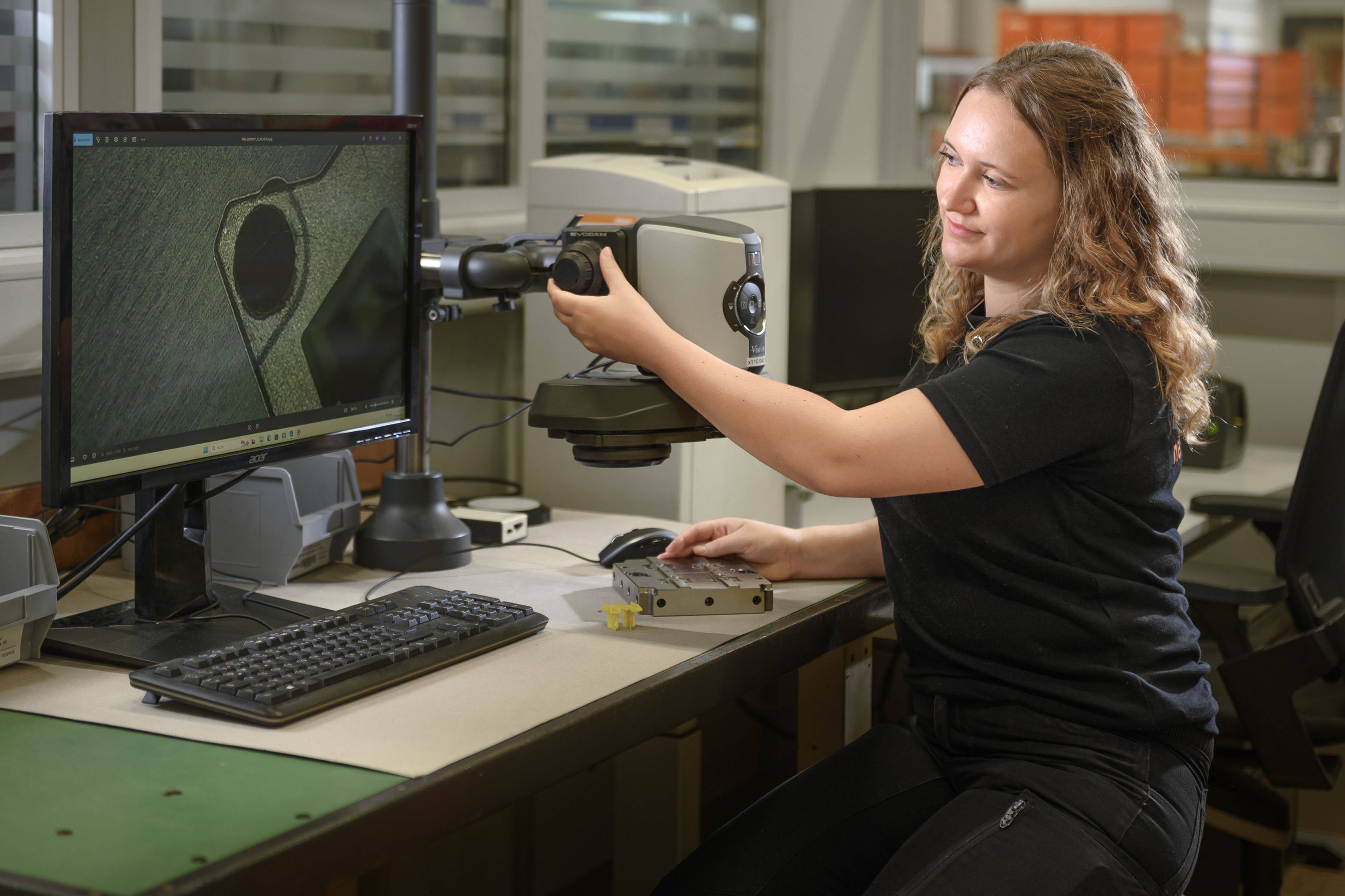 Lehrling der Werkzeugbautechnik bei Blum führt im Messraum eine Qualitätskontrolle an einem Werkzeugbauteil durch. Mithilfe moderner Messtechnik werden Bauteile präzise geprüft und analysiert. Die Ausbildung Werkzeugbautechnik mit Schwerpunkt Prozess- und Projektmanagement vermittelt Kompetenzen in Fertigung, Qualitätssicherung, Wartung und Optimierung von Werkzeugen.