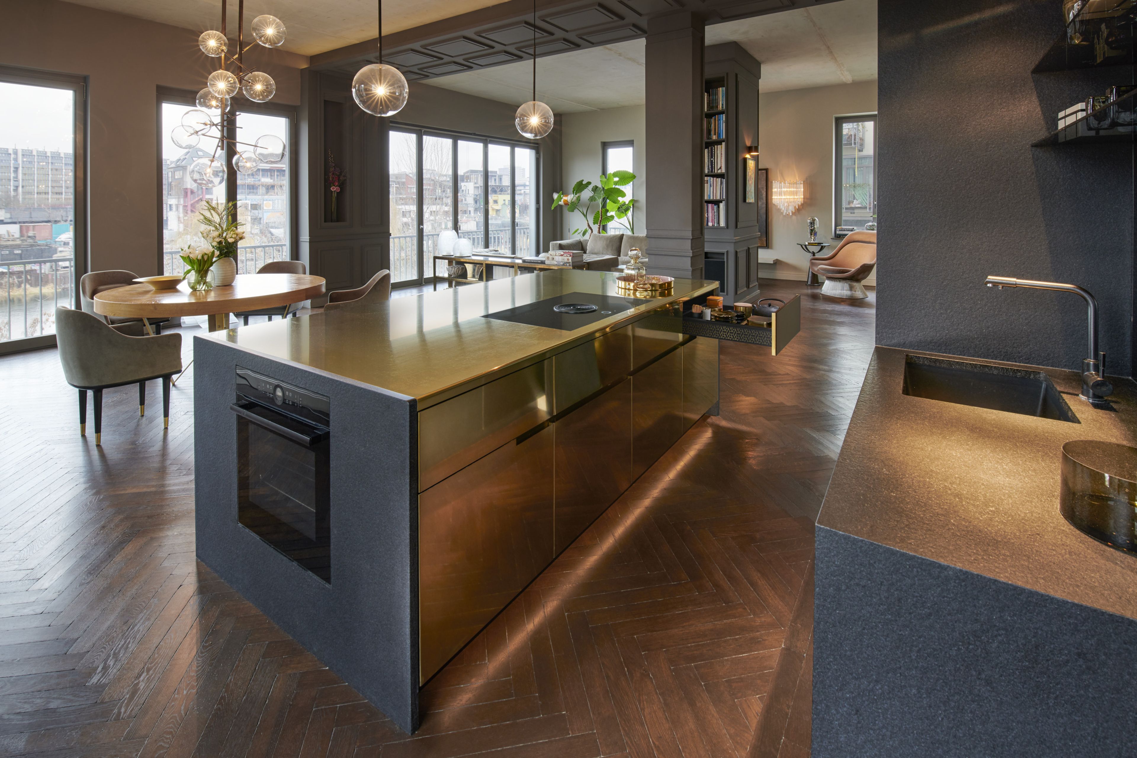 An island kitchen with gold metal surfaces