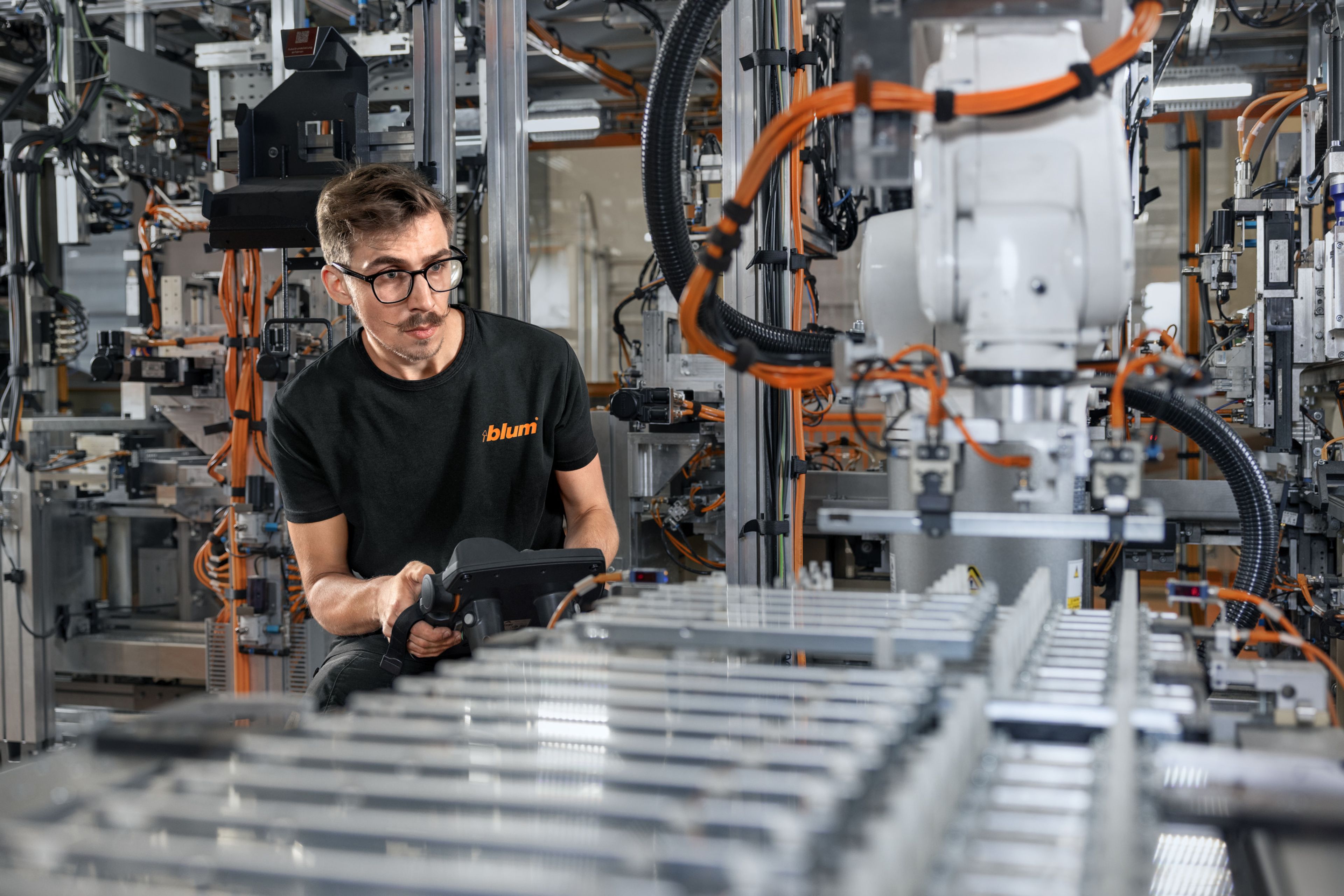 Das Bild zeigt einen Lehrling der gerade die Roboterfahr eines Roboters neu einstellt.