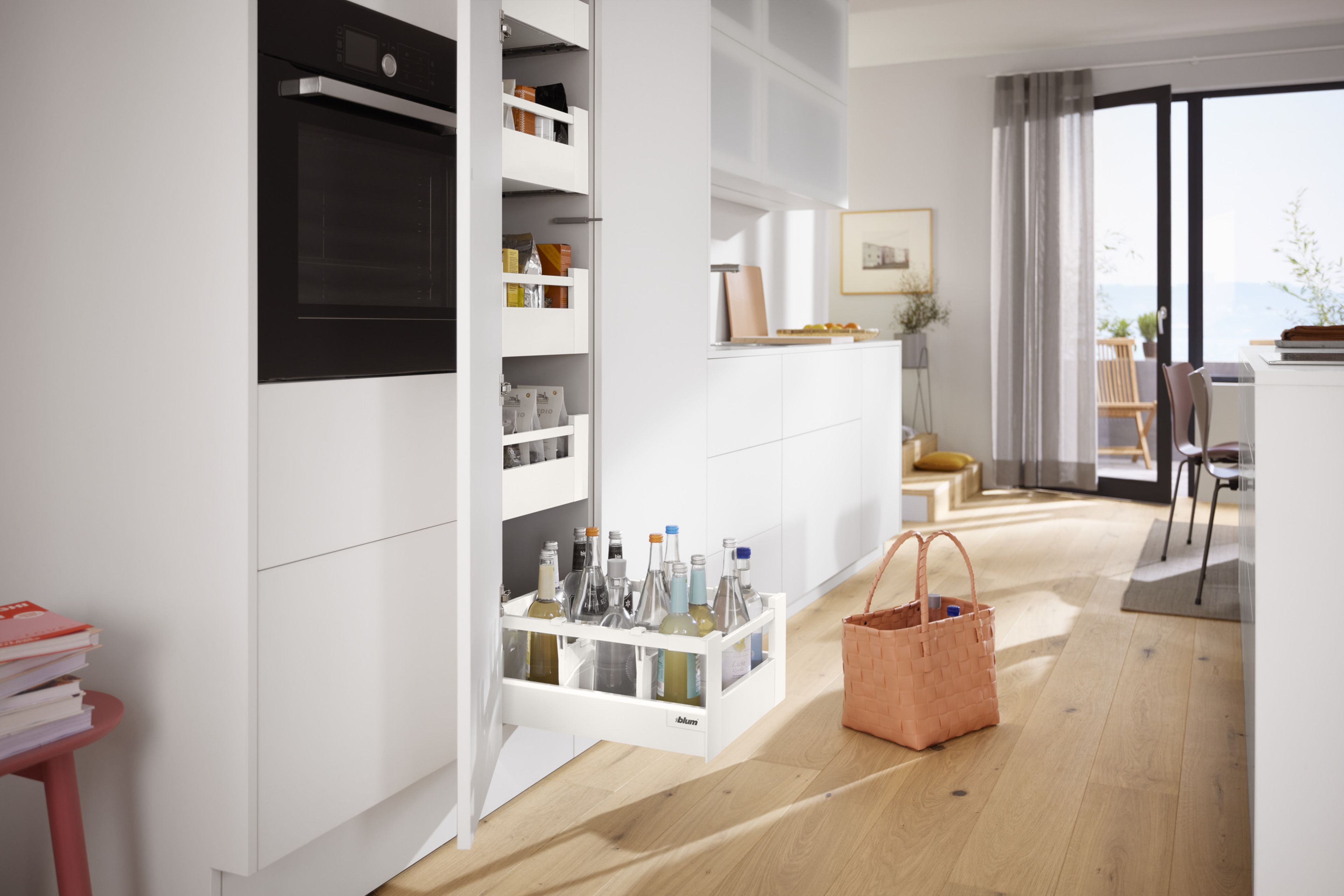 A bottom pantry drawer pulled out to show drink bottles and cartons