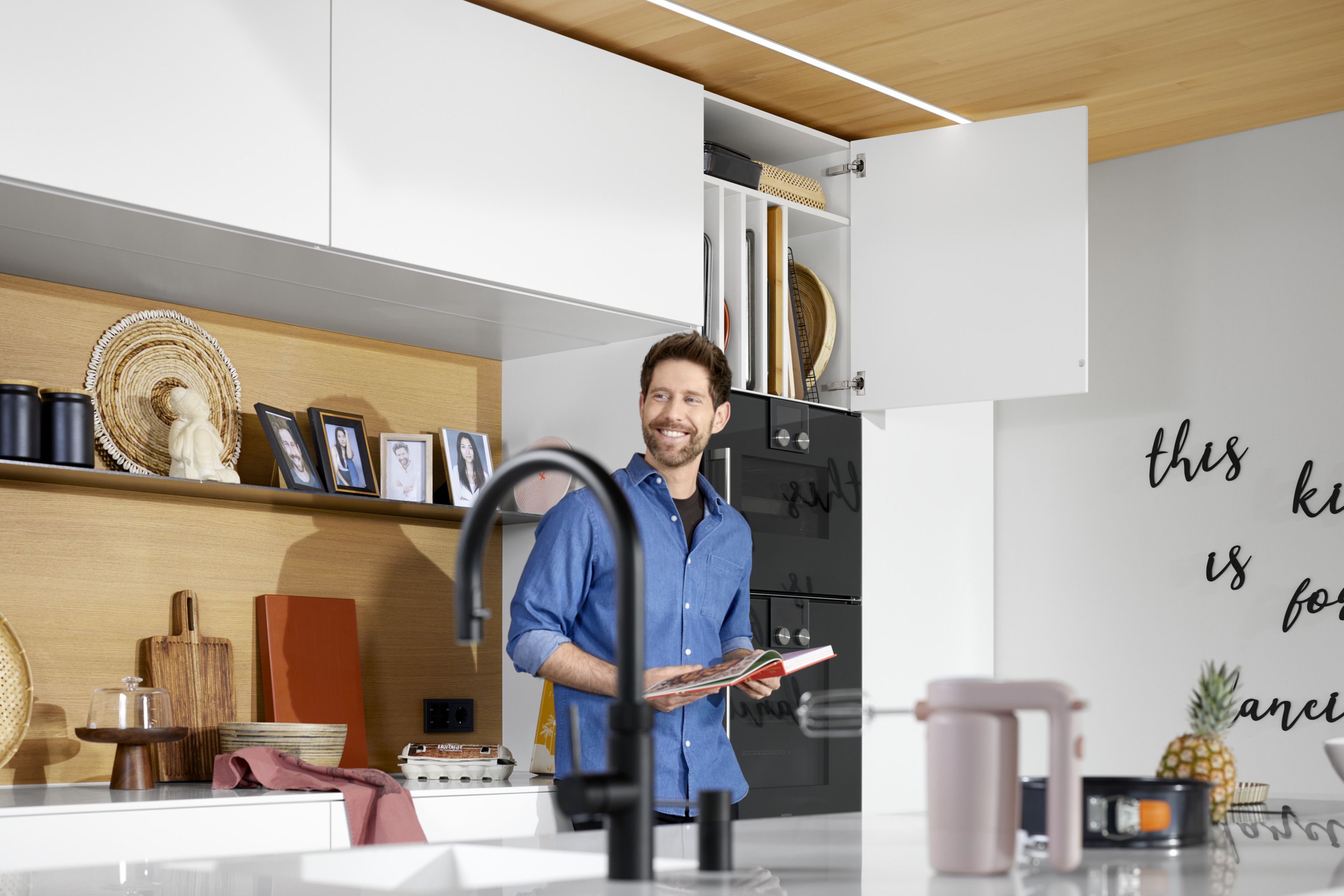 A man stands in a white island kitchen