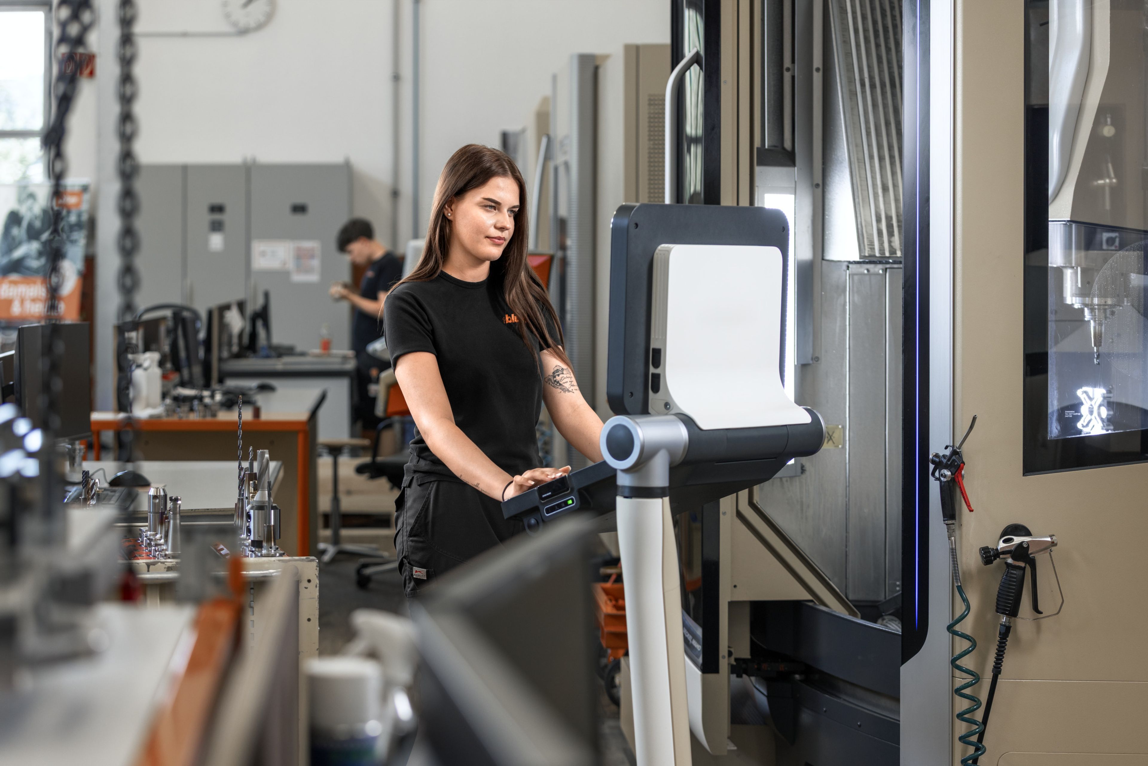 Das Bild zeigt einen Zerspanungstechniker bei Blum am Programmieren an der CNC-Fräsmaschine. 