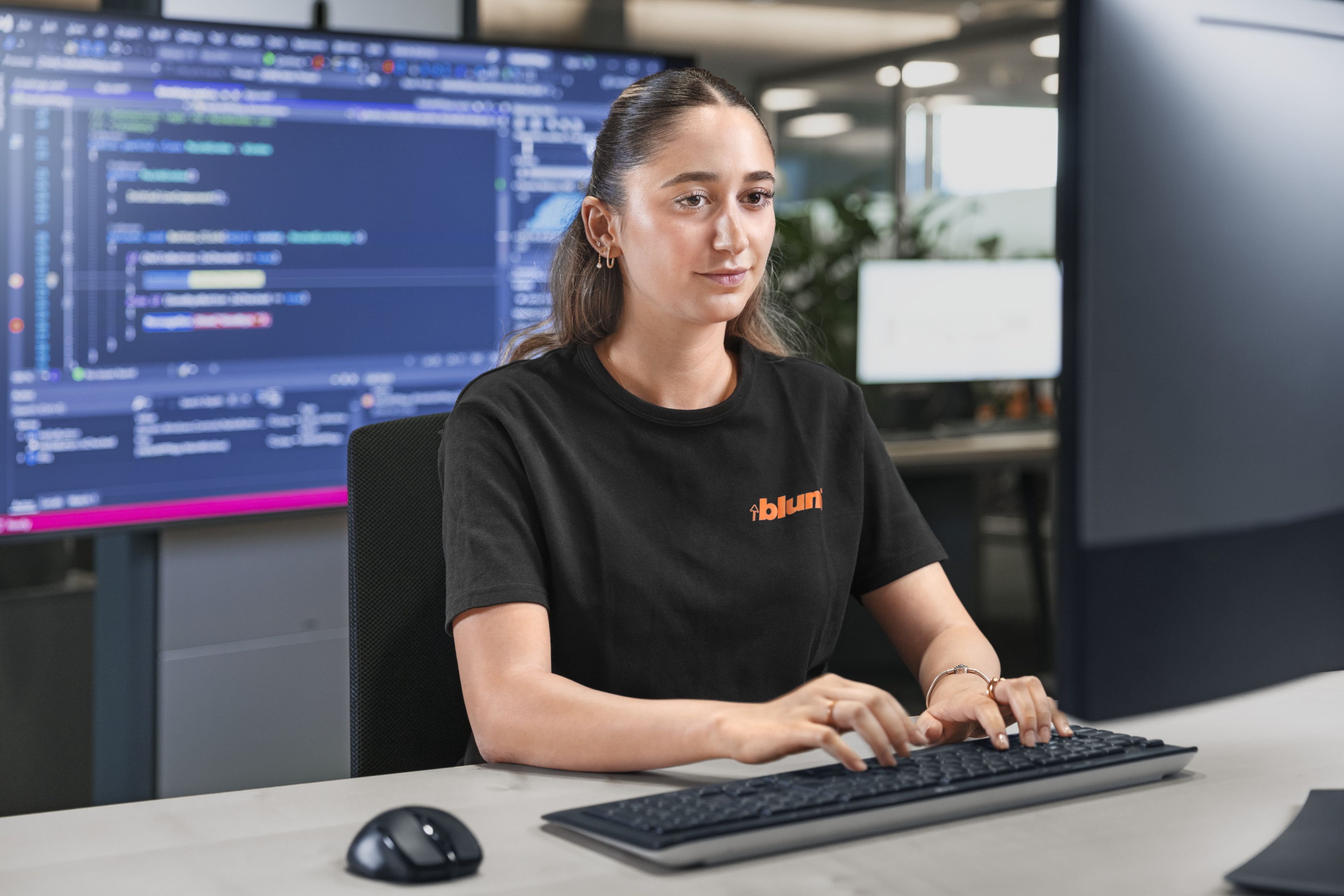 Das Bild zeigt ein Trainee wie sie gerade am PC am arbeiten ist. 