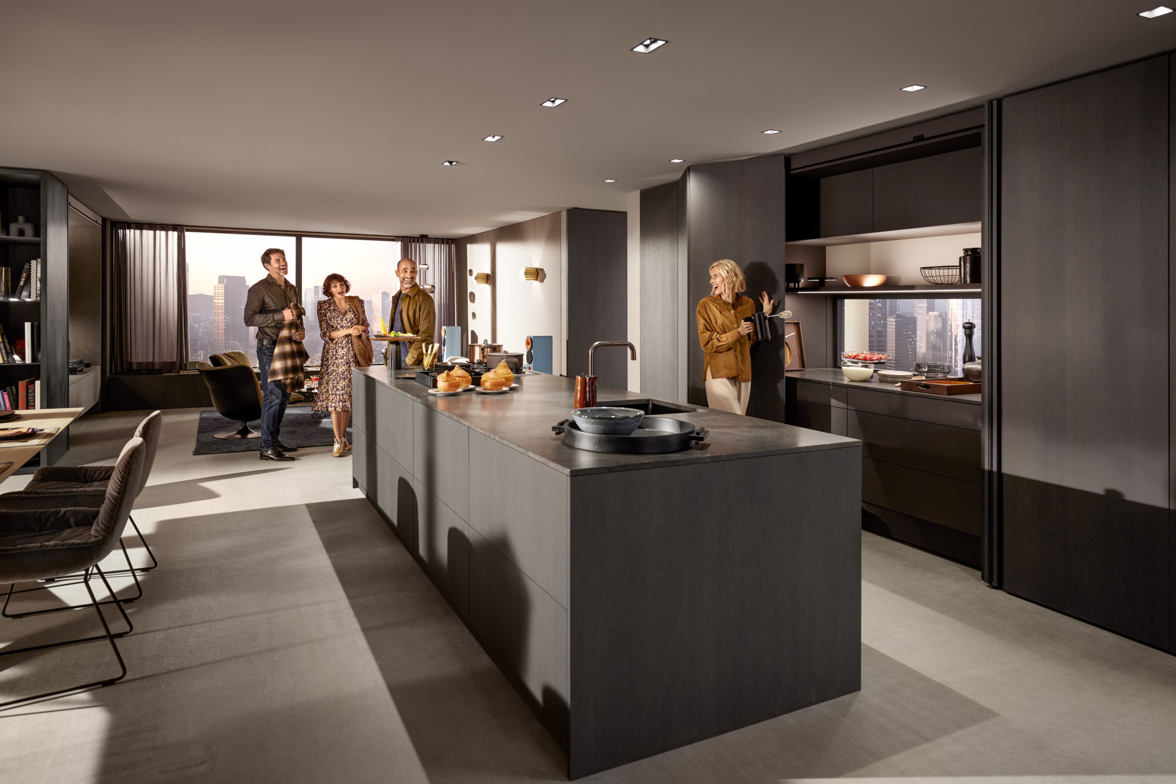 A dark-coloured island kitchen with closed REVEGO pocket system