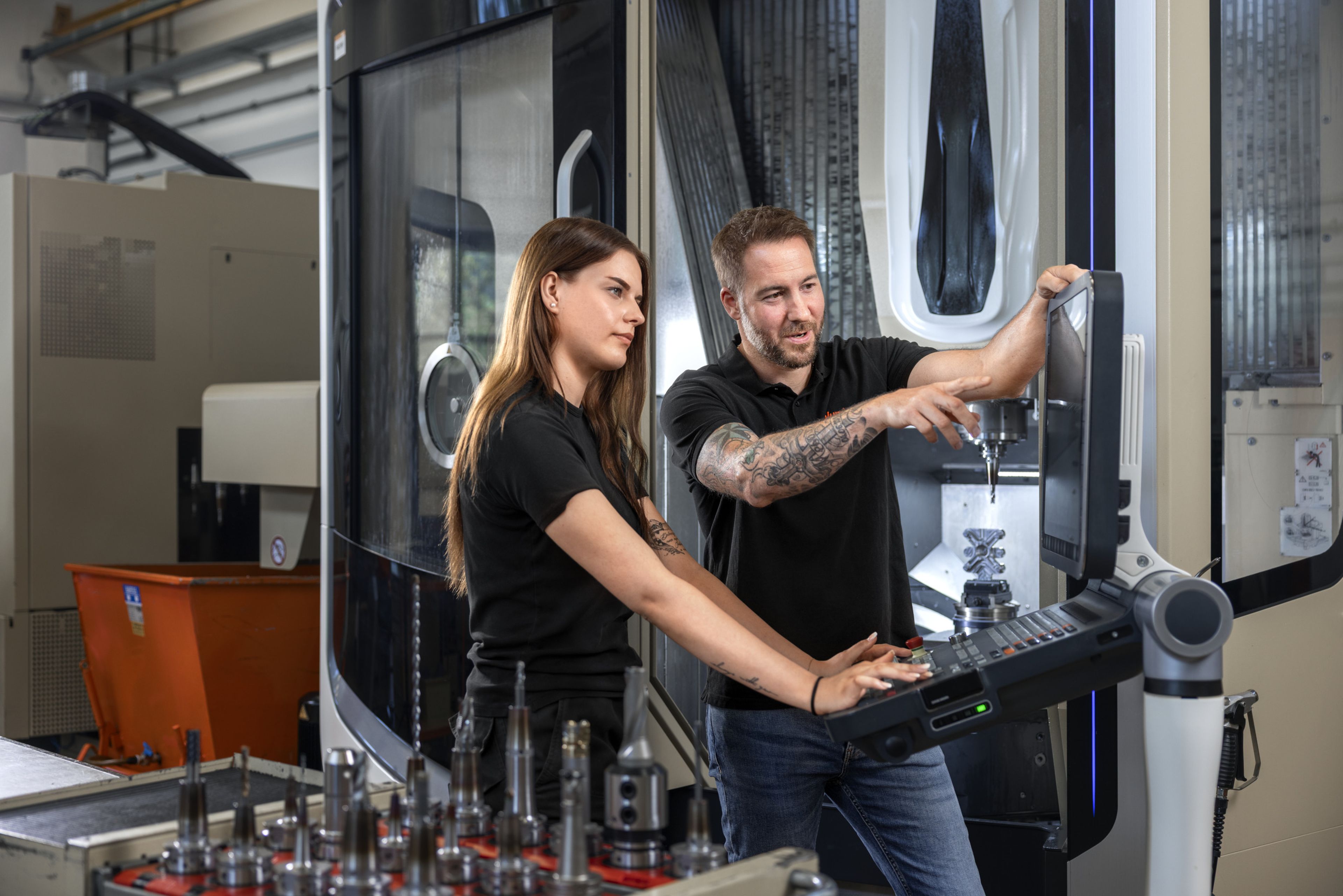 Das Bild zeigt wie ein Ausbilder und sein Lehrling eine fertige Programmierung durchsprechen und kontrollieren.