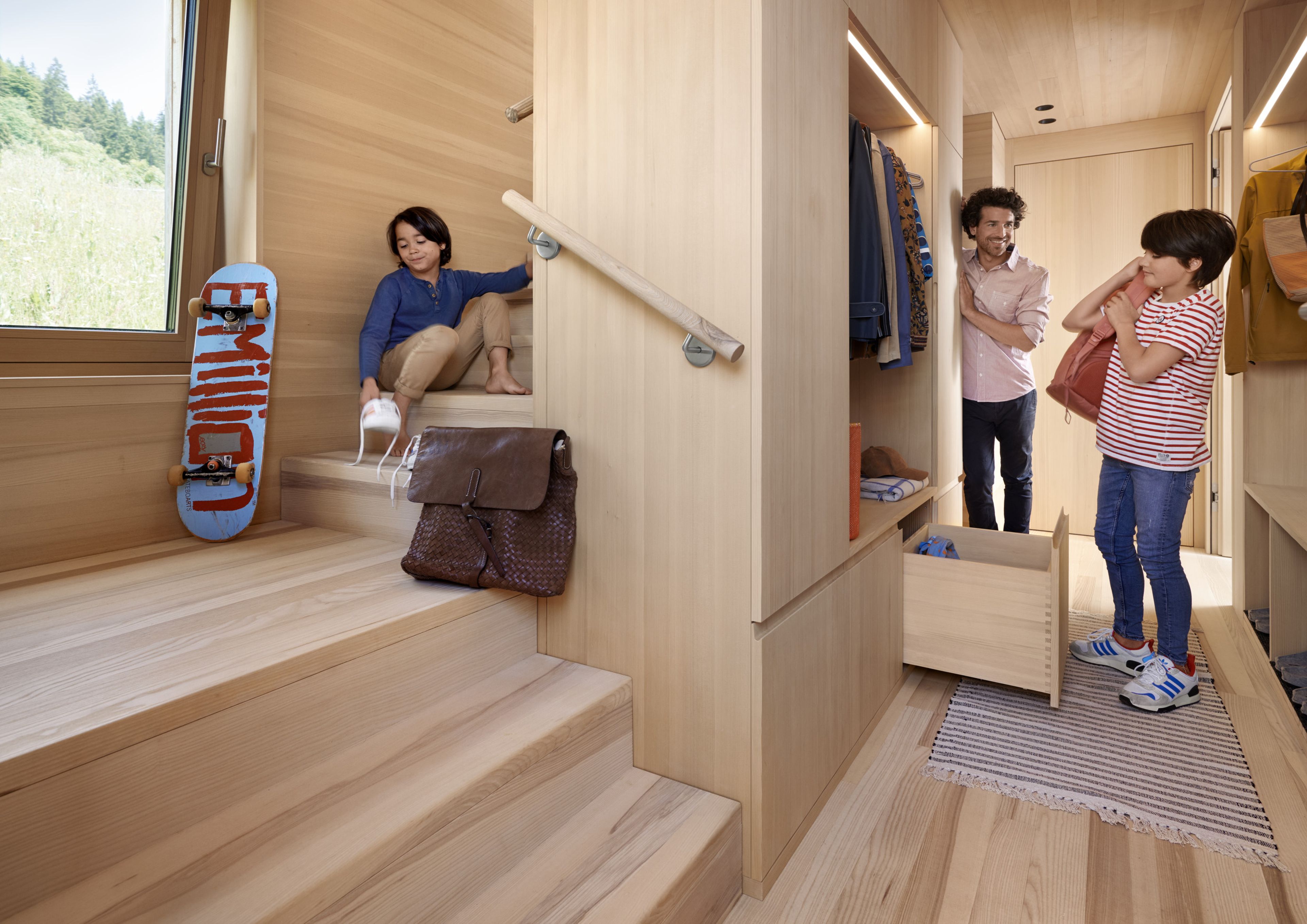 A family in a stairwell designed entirely in wood, complete with hallway cabinet