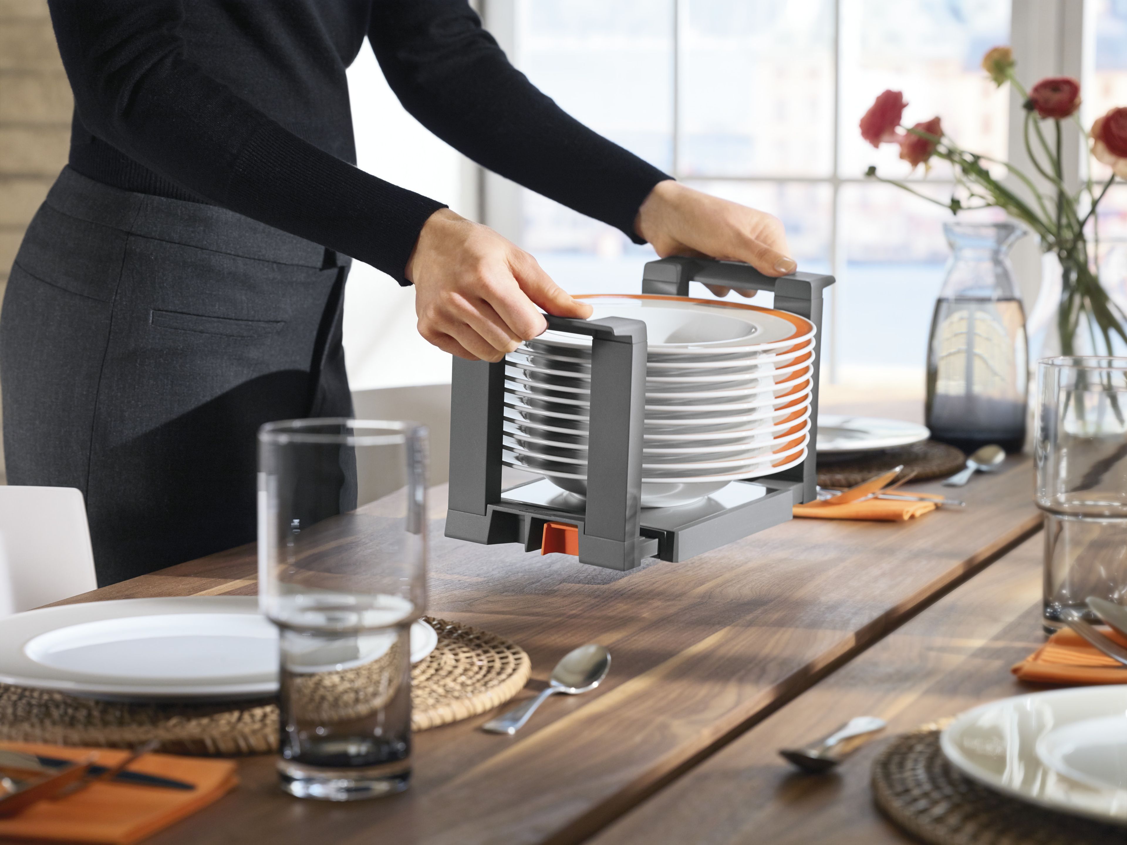 A woman carrying a stack of plates in a plate holder