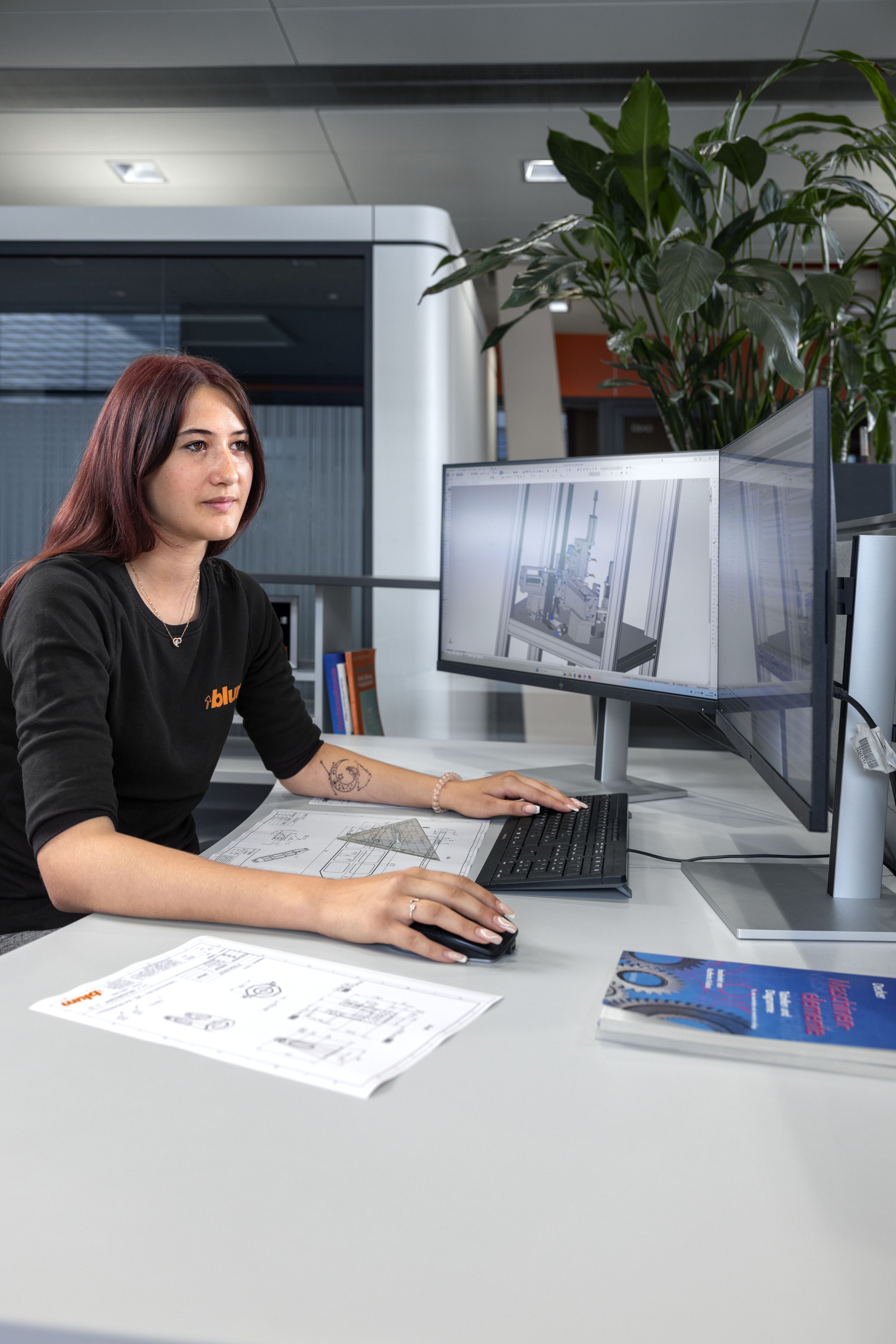Das Bild zeigt einen Lehrling in der Konstruktion bei Blum, die gerade eine CAD-Zeichnung anfertigt. 