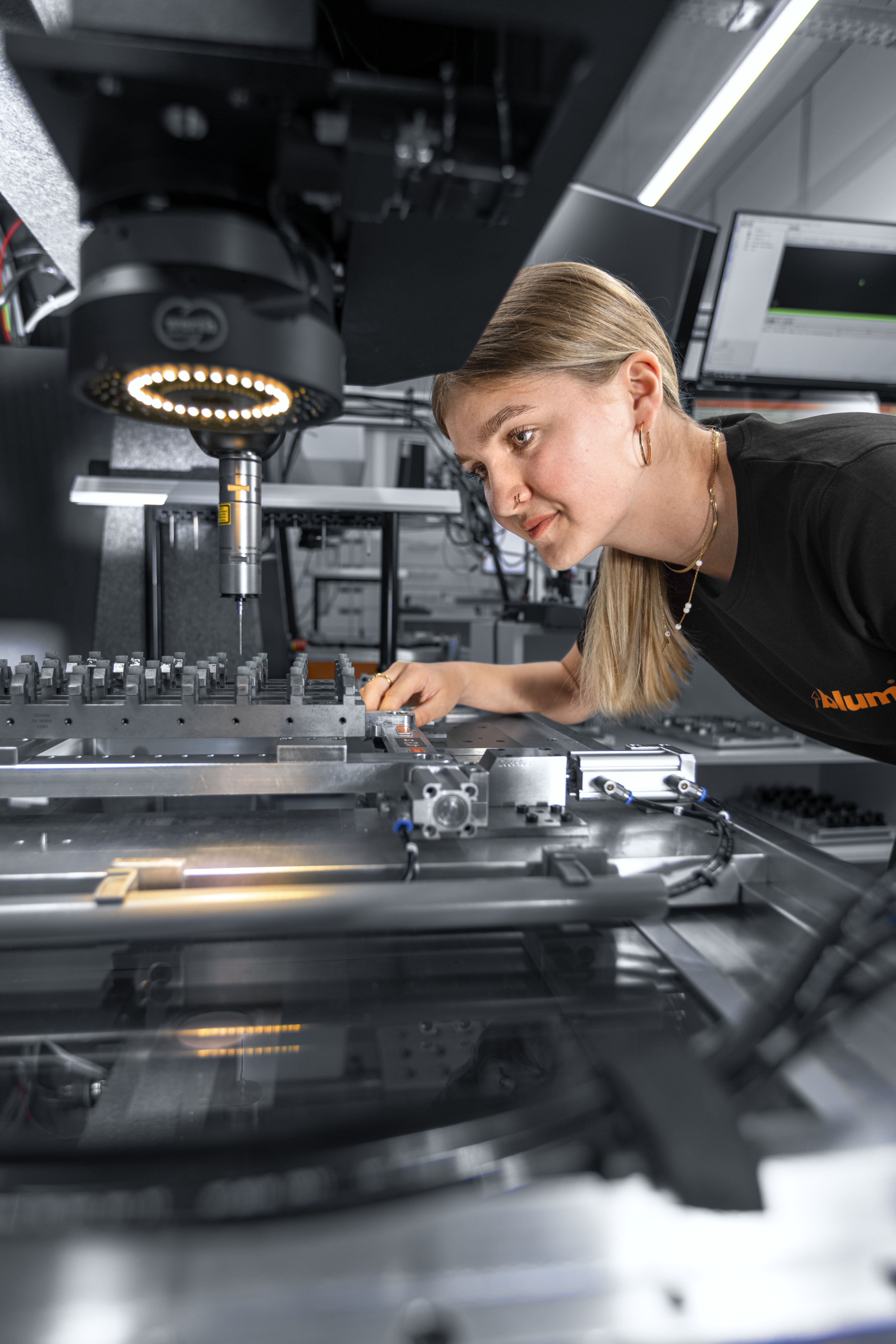 Das Bild zeigt einen Lehrling der Fertigungsmesstechnik die gerade ein Bauteil mit einem Streifenlichtprojektor ausmisst. 
