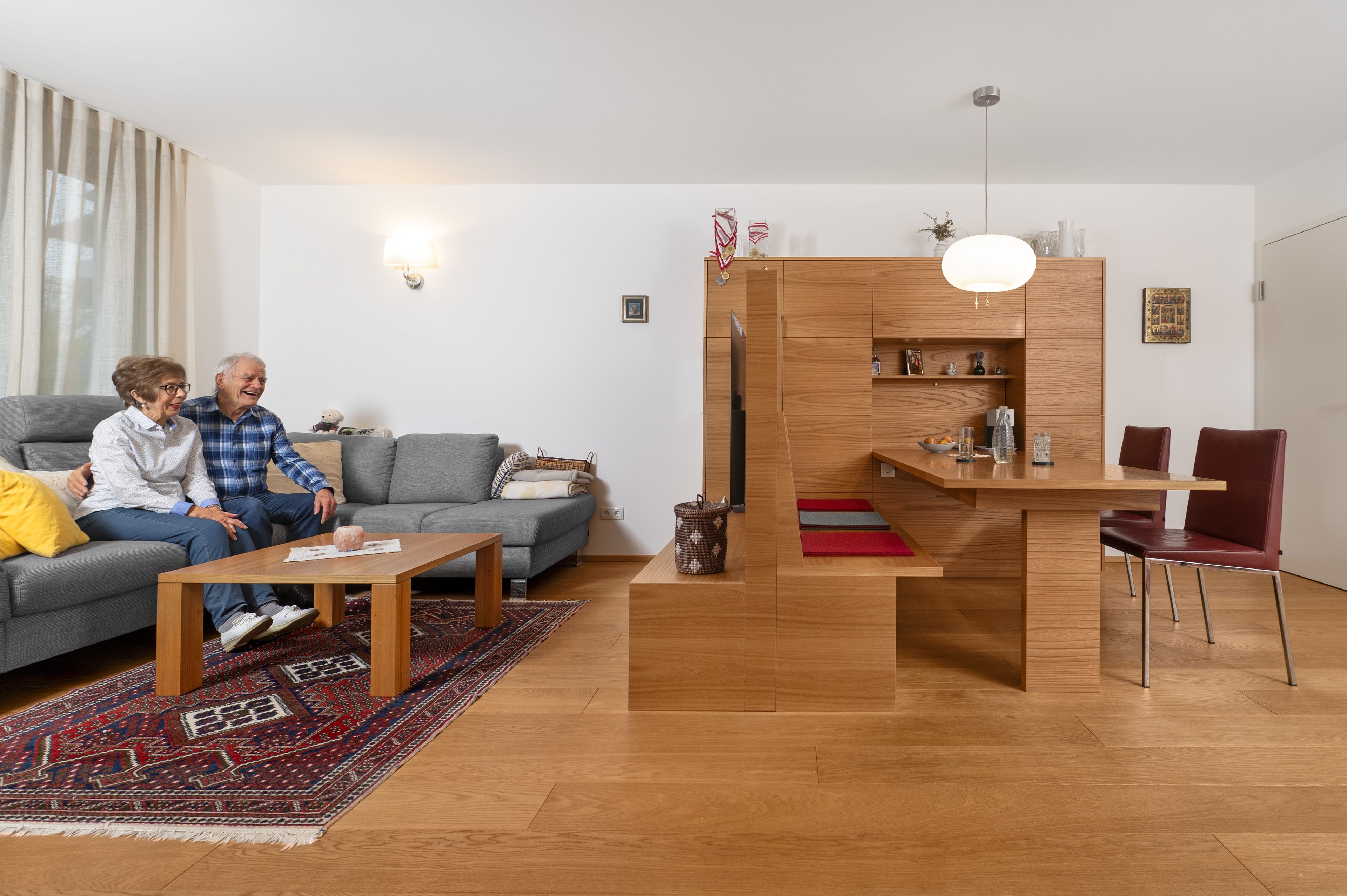 Ein Paar sitzt auf einer Couch in einem offenen Wohn-Esszimmer