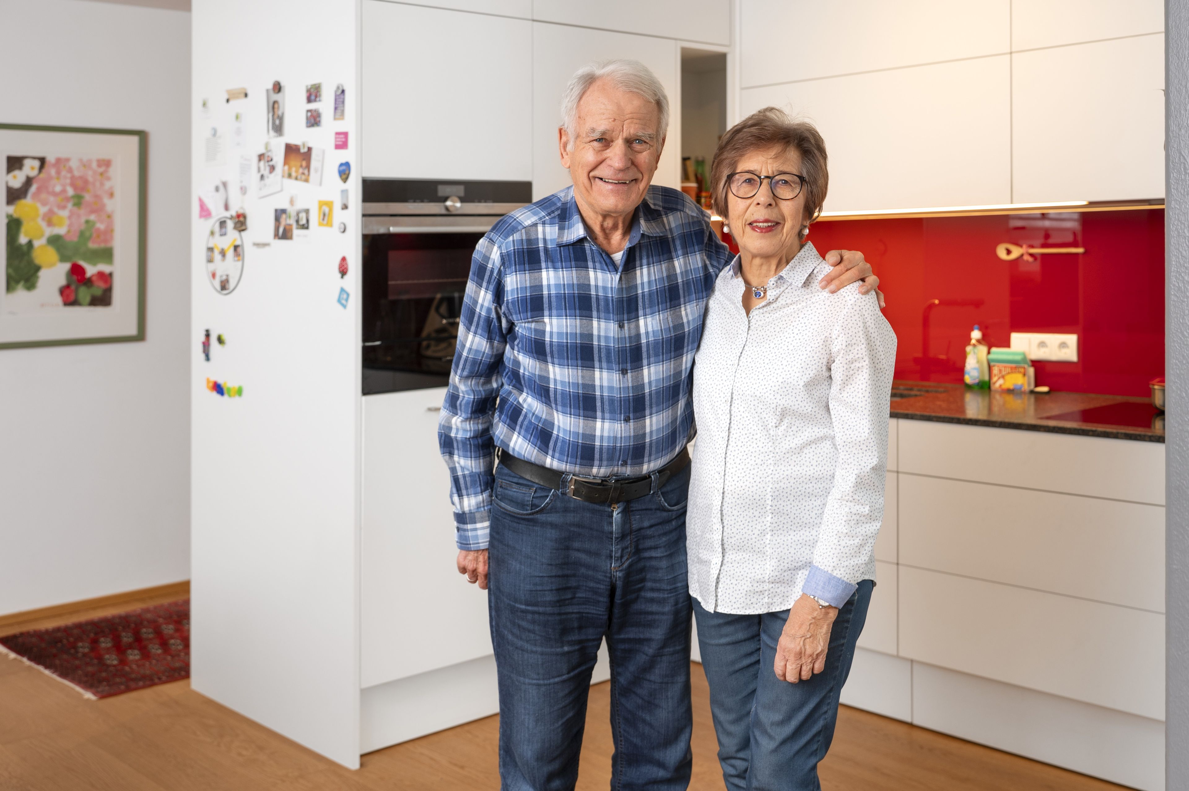 Ein Paar steht vor ihrer weißen L-Küche