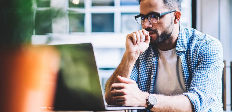 thoughtful remote worker using a laptoop