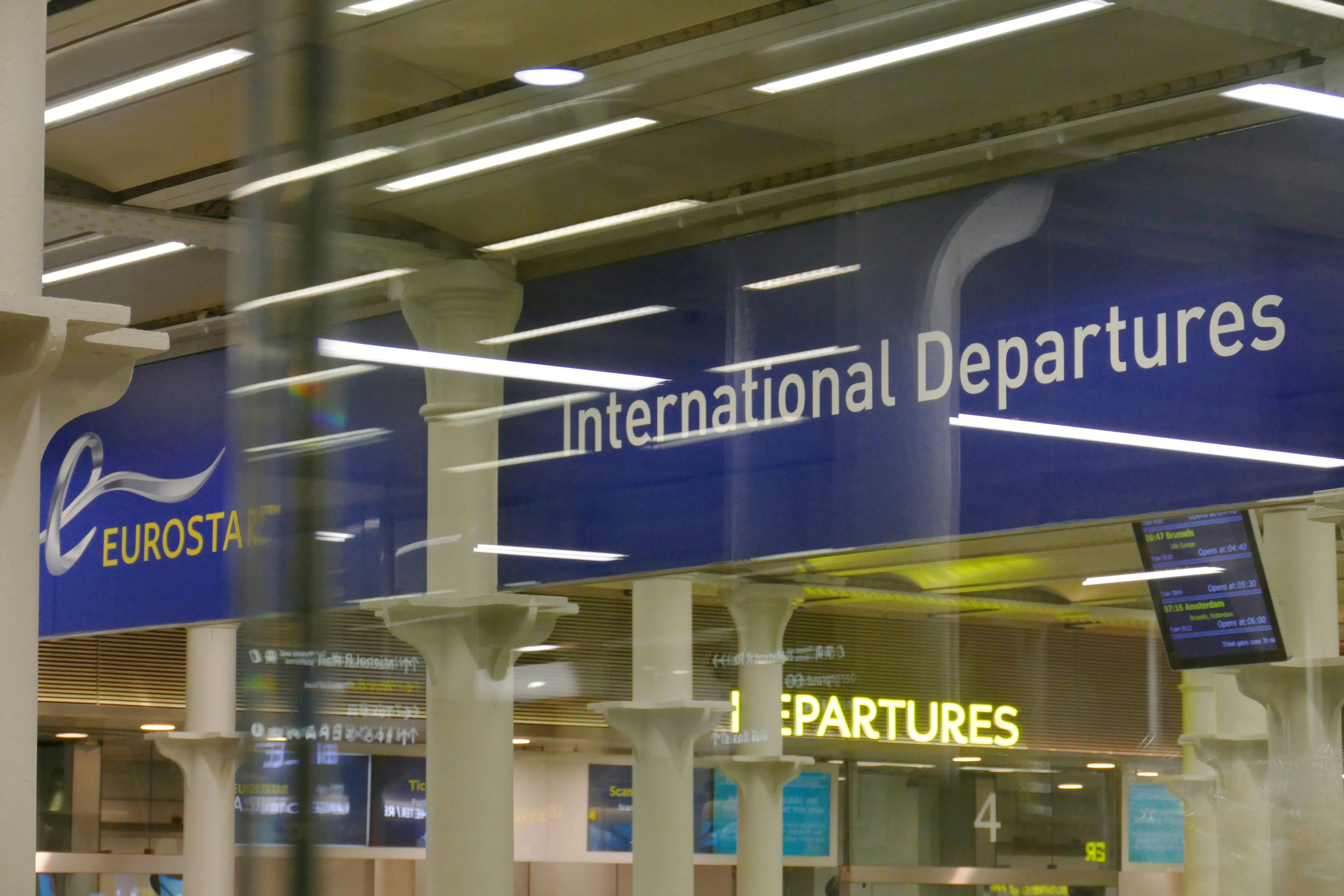 View of Eurostar International Departures signs in a station, showing platform details and overhead lighting.