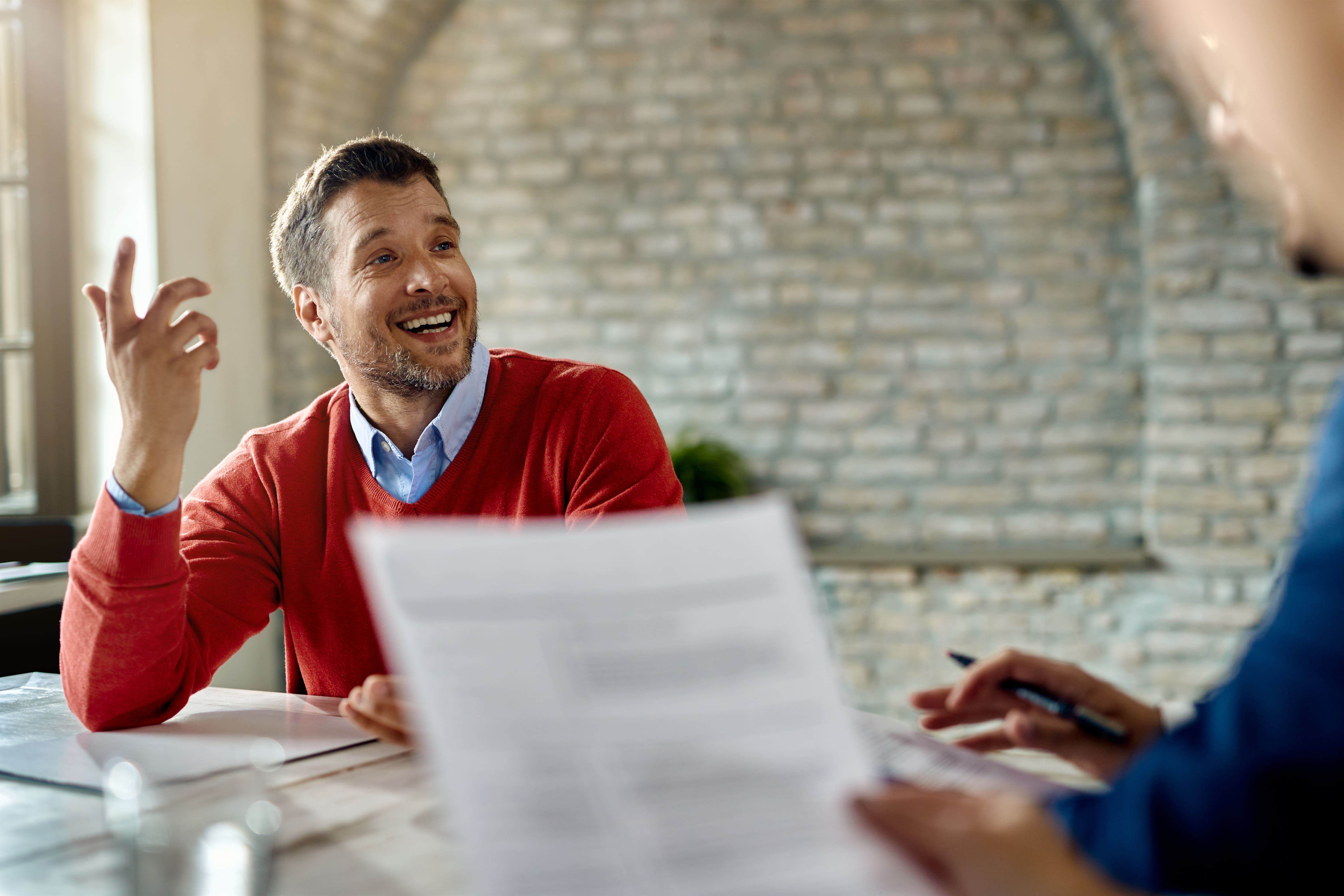 happy male candidate communicating with member human resource team job interview office
