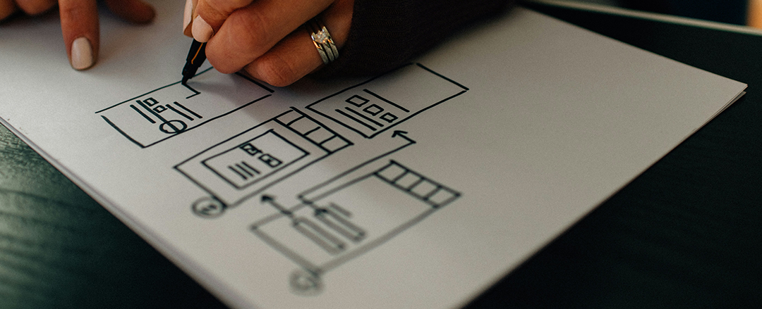 Designer sketching user interface wireframes by hand, illustrating rapid prototyping, UX design, creativity and natural design workflows.