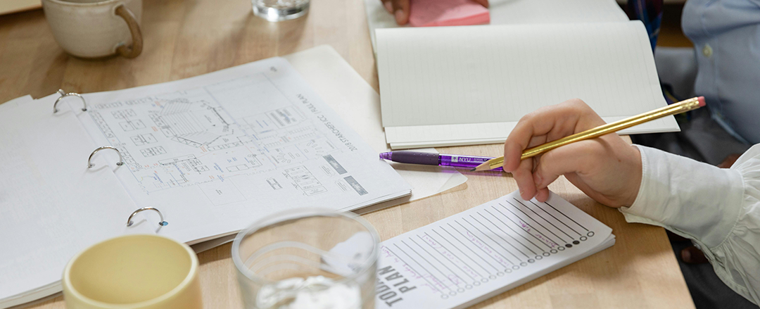 Workspace with handwritten notes, planner, and pen, illustrating analog productivity tools in an office setting