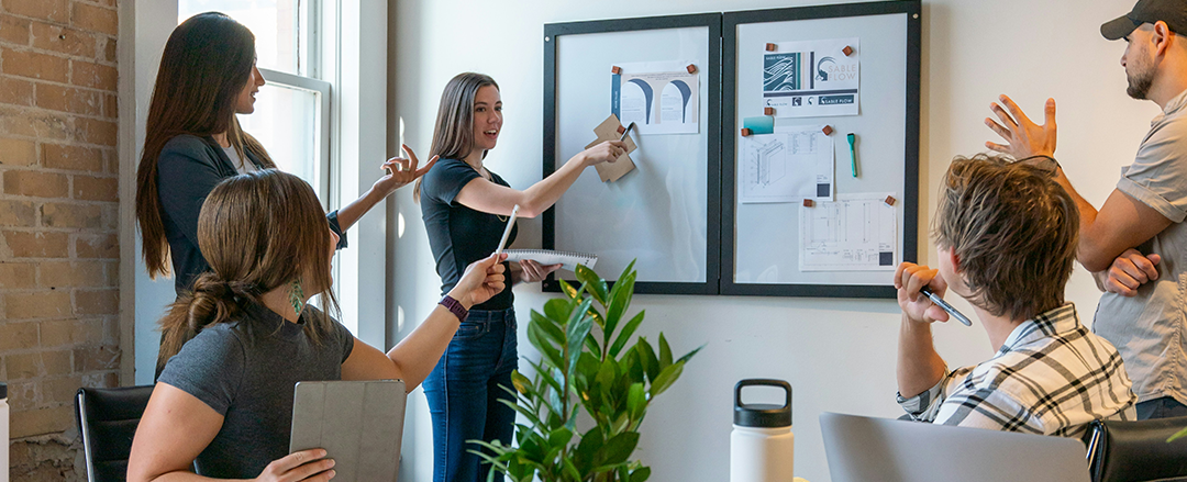 Team presenting concepts on wall boards in a meeting room