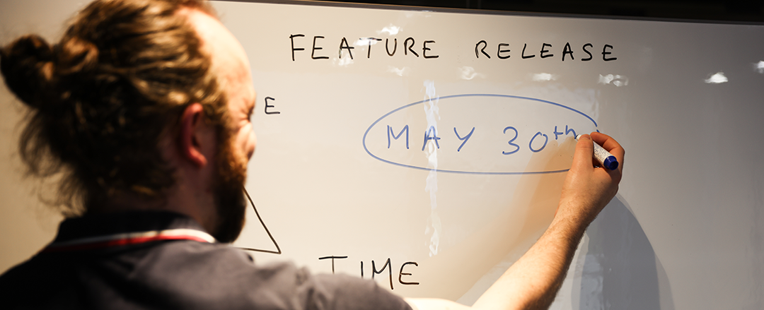 A person writing on a whiteboard during a meeting, illustrating how handwriting on visual collaboration tools supports idea sharing, engagement, and hybrid teamwork.