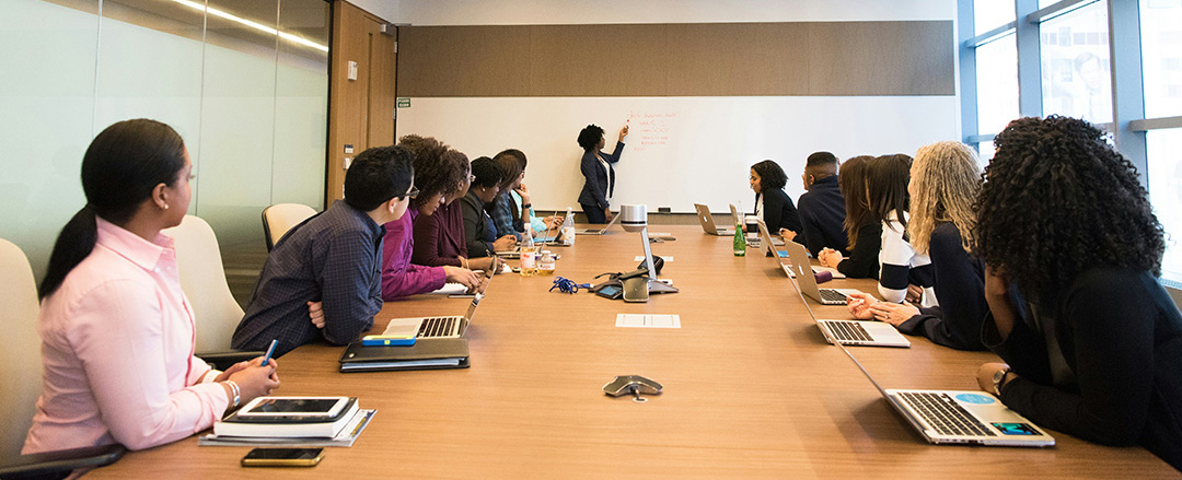 Team in a conference room using a large whiteboard illustrating hybrid meeting collaboration and shared workspace interaction