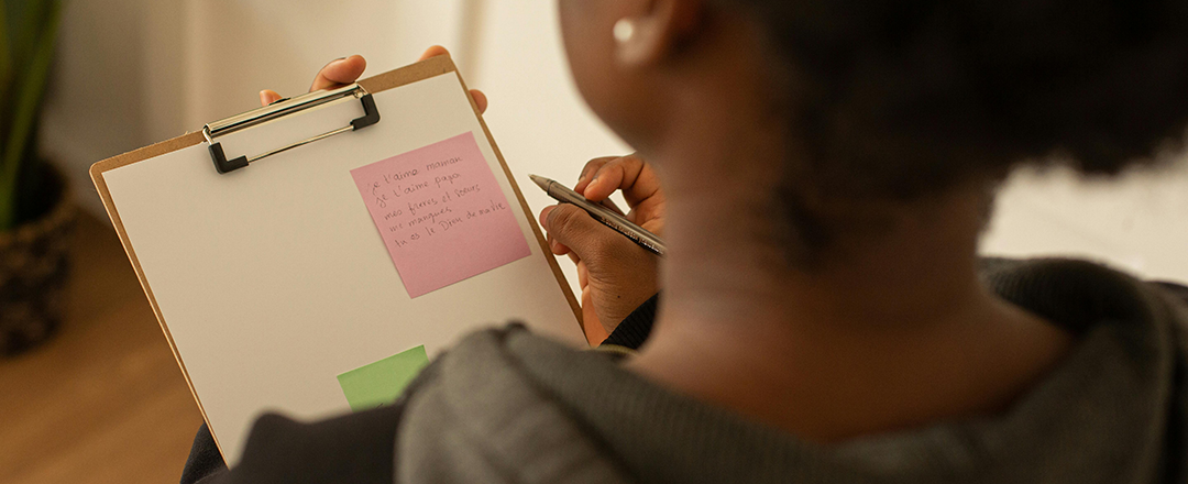 Employee writing handwritten notes on a clipboard with sticky notes, illustrating focus and analog thinking at work