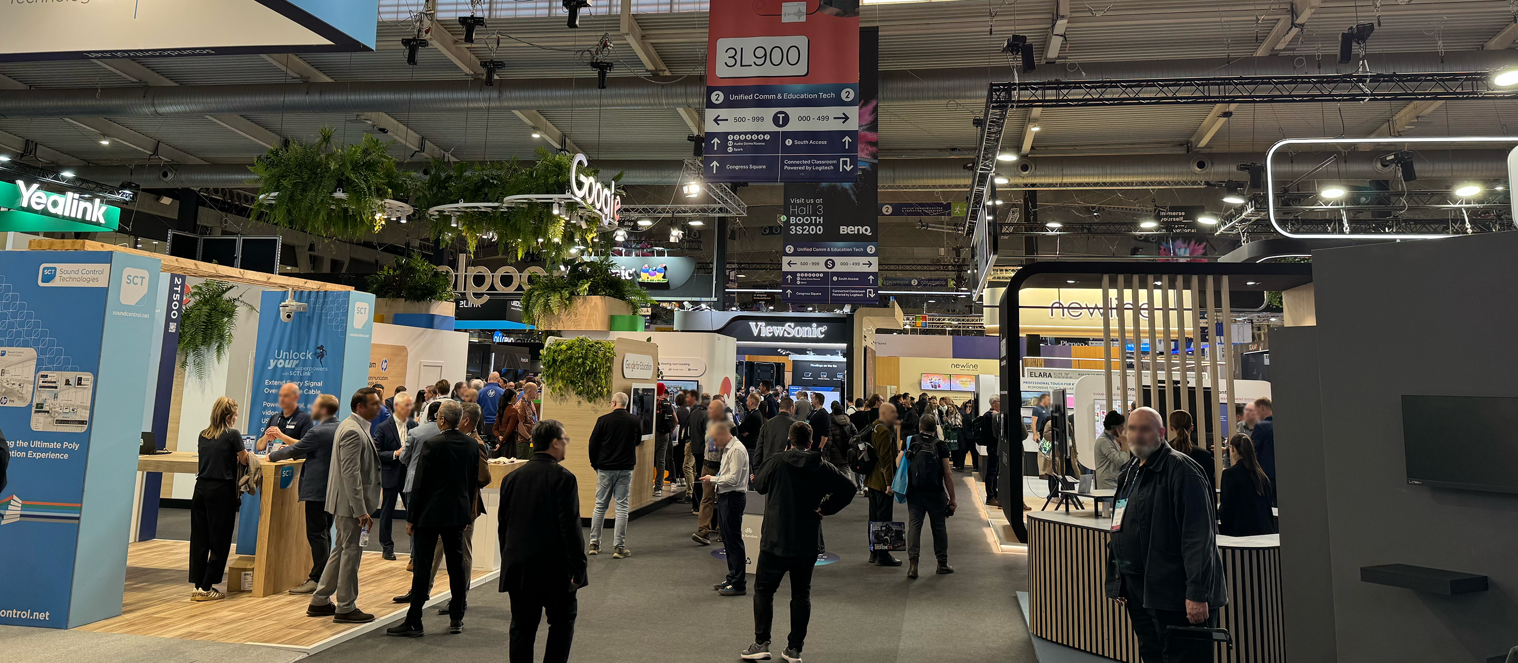 Busy exhibition hall at ISE 2026 in Barcelona featuring major AV and unified communication technology booths and industry professionals networking.