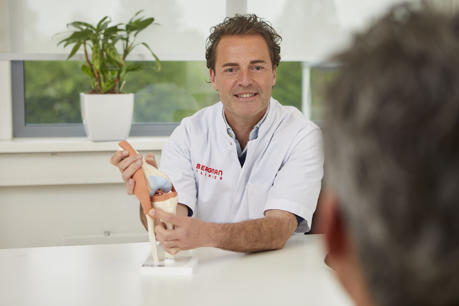 Bewegen_Breda_arts Robert van Dijck met anatomie model knie