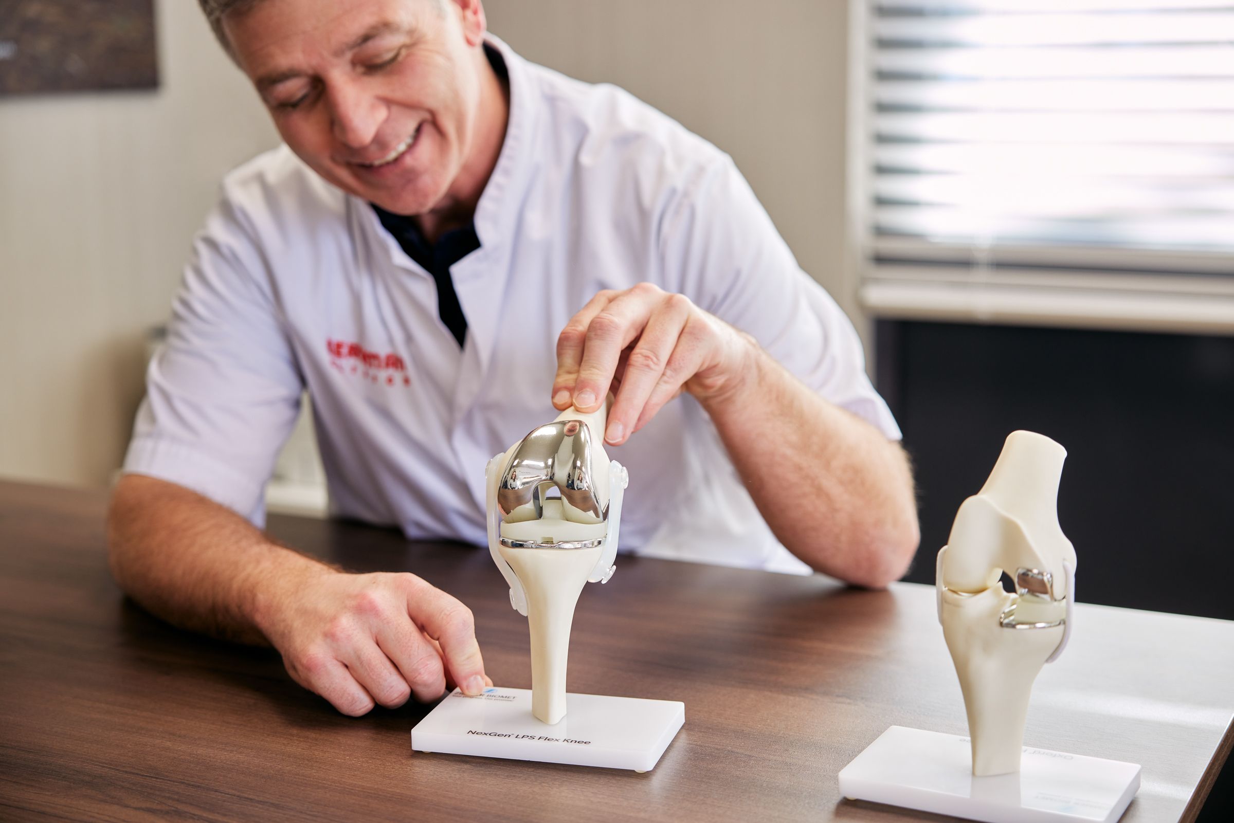 Orthopedisch chirurg in spreekkamer met anatomie model knie