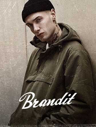 Person in a green jacket and black beanie leaning against a wall, with "Brandit" text overlayed at the bottom.