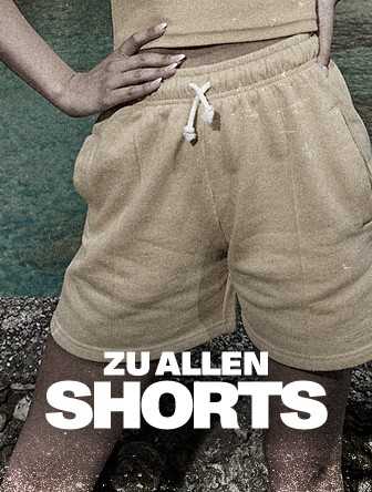 Person wearing beige drawstring shorts stands with hands on hips; text reads "ZU ALLEN SHORTS."